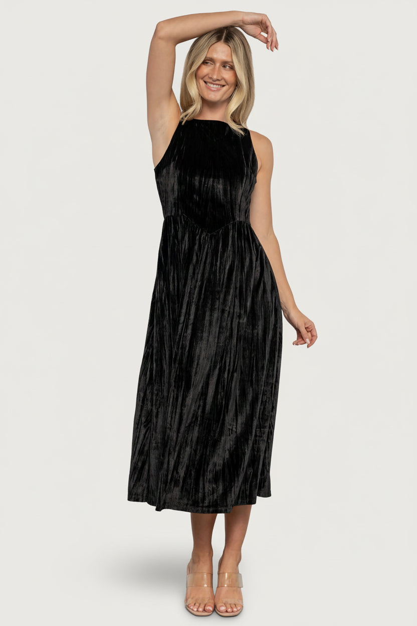 Full-length shot of the black crinkled velvet midi dress on model, showing natural drape of unlined skirt and silhouette.