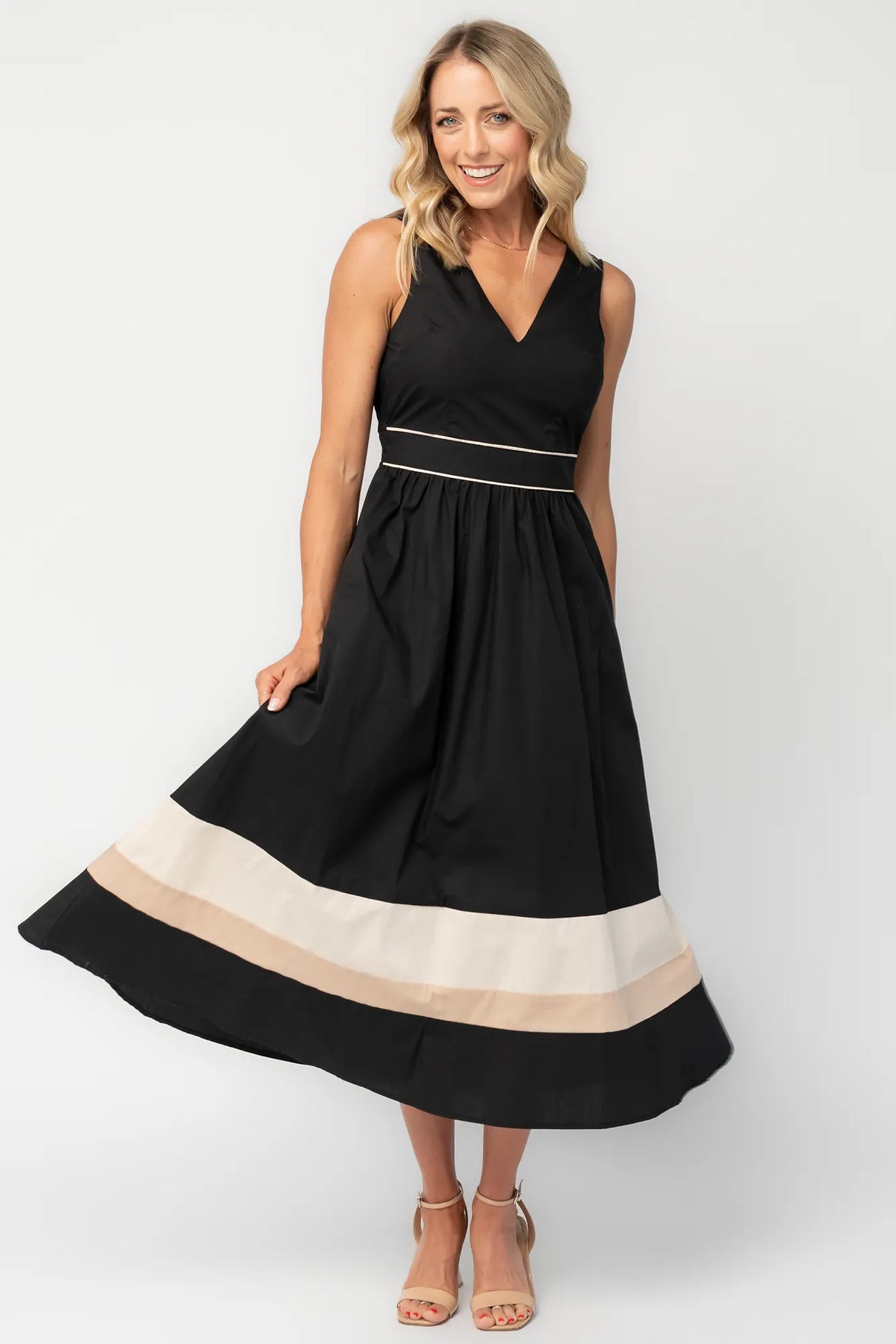Model wearing a black midi dress with a V-neckline, tank straps, and a fitted bodice.
