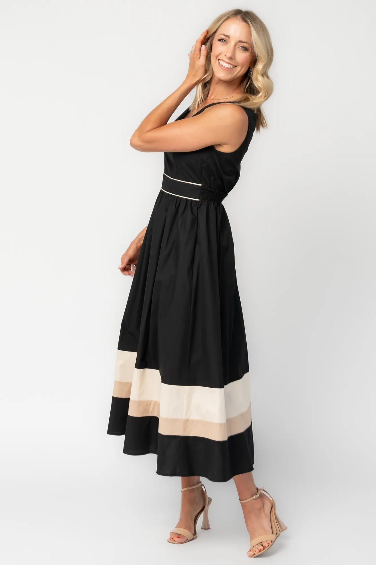 Model wearing a black midi dress with a V-neckline, tank straps, and a fitted bodice.