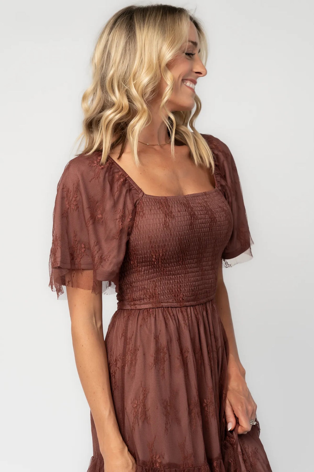 Model wearing a mahogany lace maxi dress with a square neckline, short sleeves, and a smocked bodice.