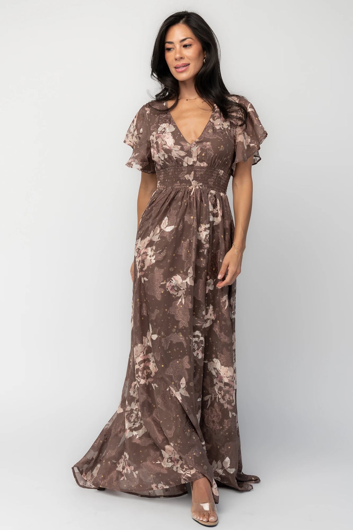 Mocha metallic floral chiffon maxi dress with a V-neckline, flutter sleeves, smocked waist, and flowing full-length skirt.
