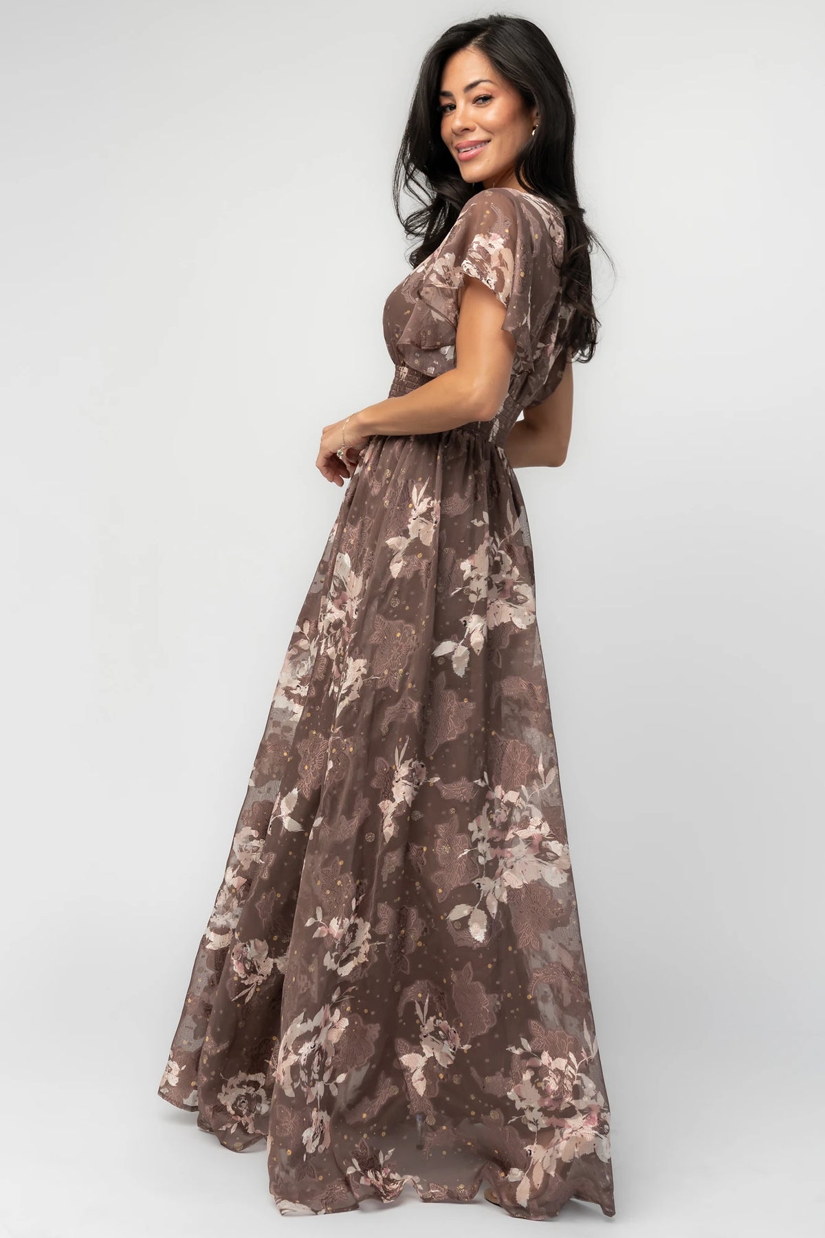 Mocha metallic floral chiffon maxi dress with a V-neckline, flutter sleeves, smocked waist, and flowing full-length skirt.
