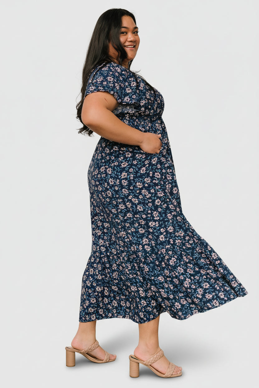 Fabric detail and pattern close-up of the blue floral Joanie dress showing sapphire, off-white, and dusty teal tones.