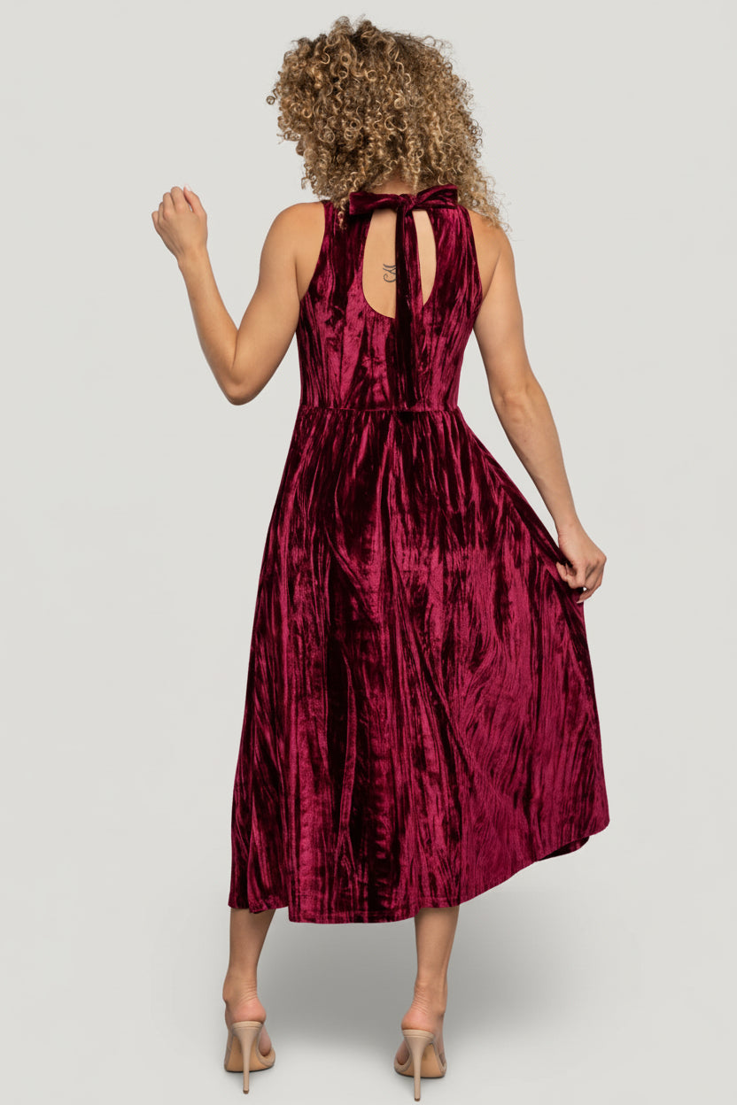 Styled look of Octavia Velvet Midi Dress in cranberry on model with accessories, showing length, fit, and pocket functionality.
