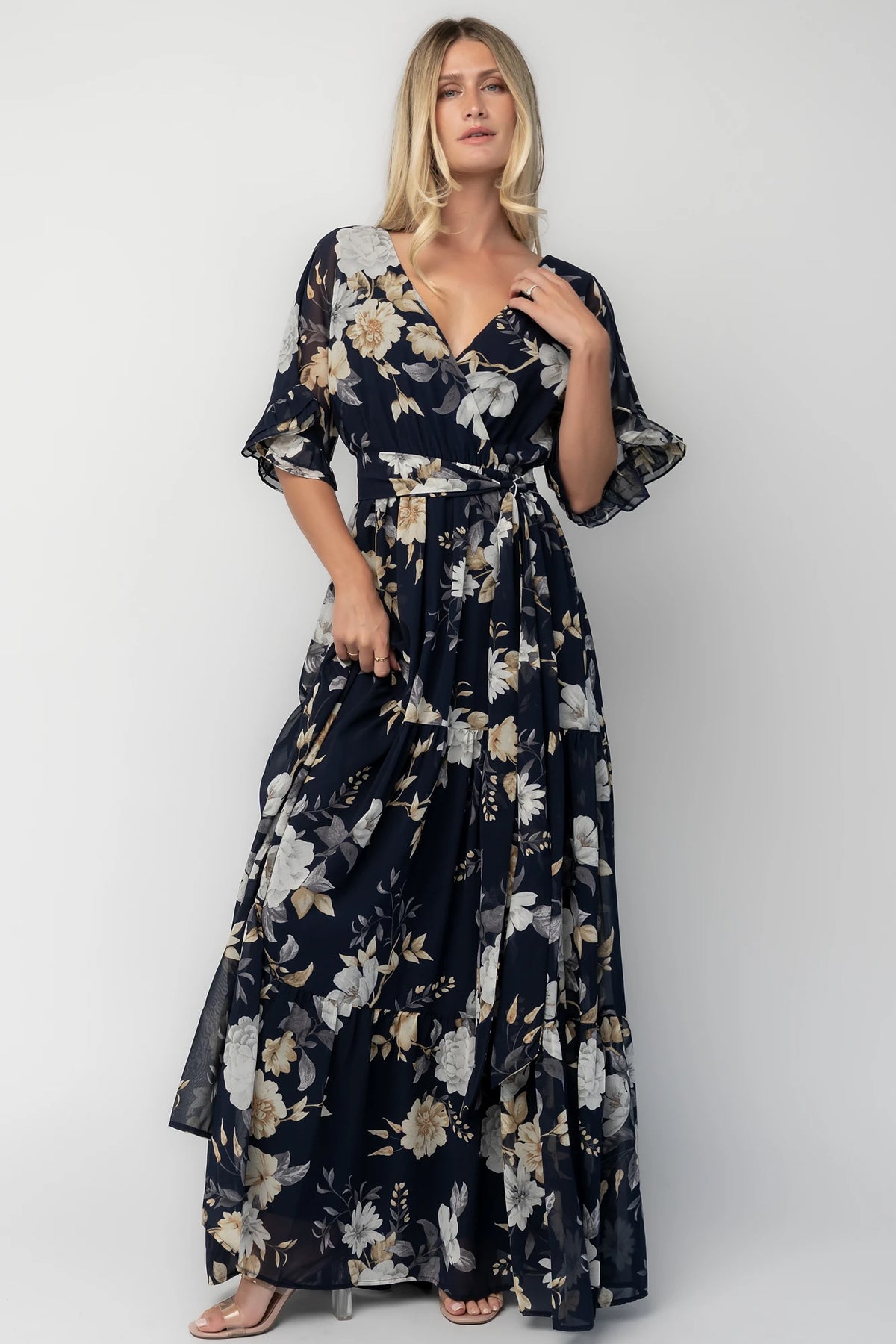 Luna Maxi Dress in Navy Floral with surplice V-neck, flutter sleeves, sash waist, and flowing tiered skirt.