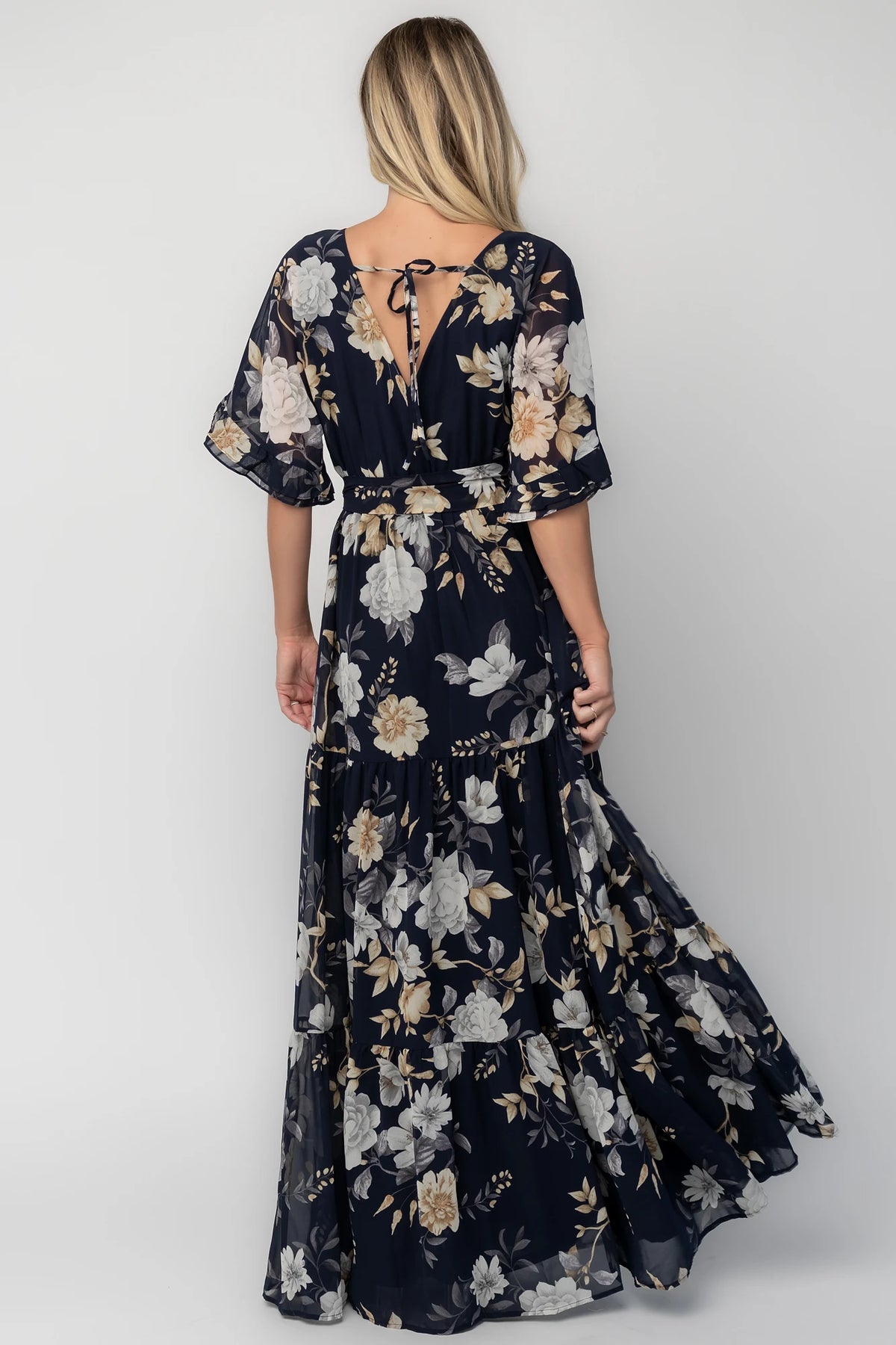 Luna Maxi Dress in Navy Floral with surplice V-neck, flutter sleeves, sash waist, and flowing tiered skirt.