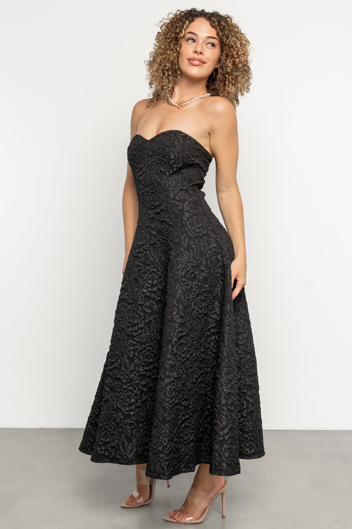 Styled look of the Selene strapless midi dress paired with metallic accessories, demonstrating evening styling options in black.
