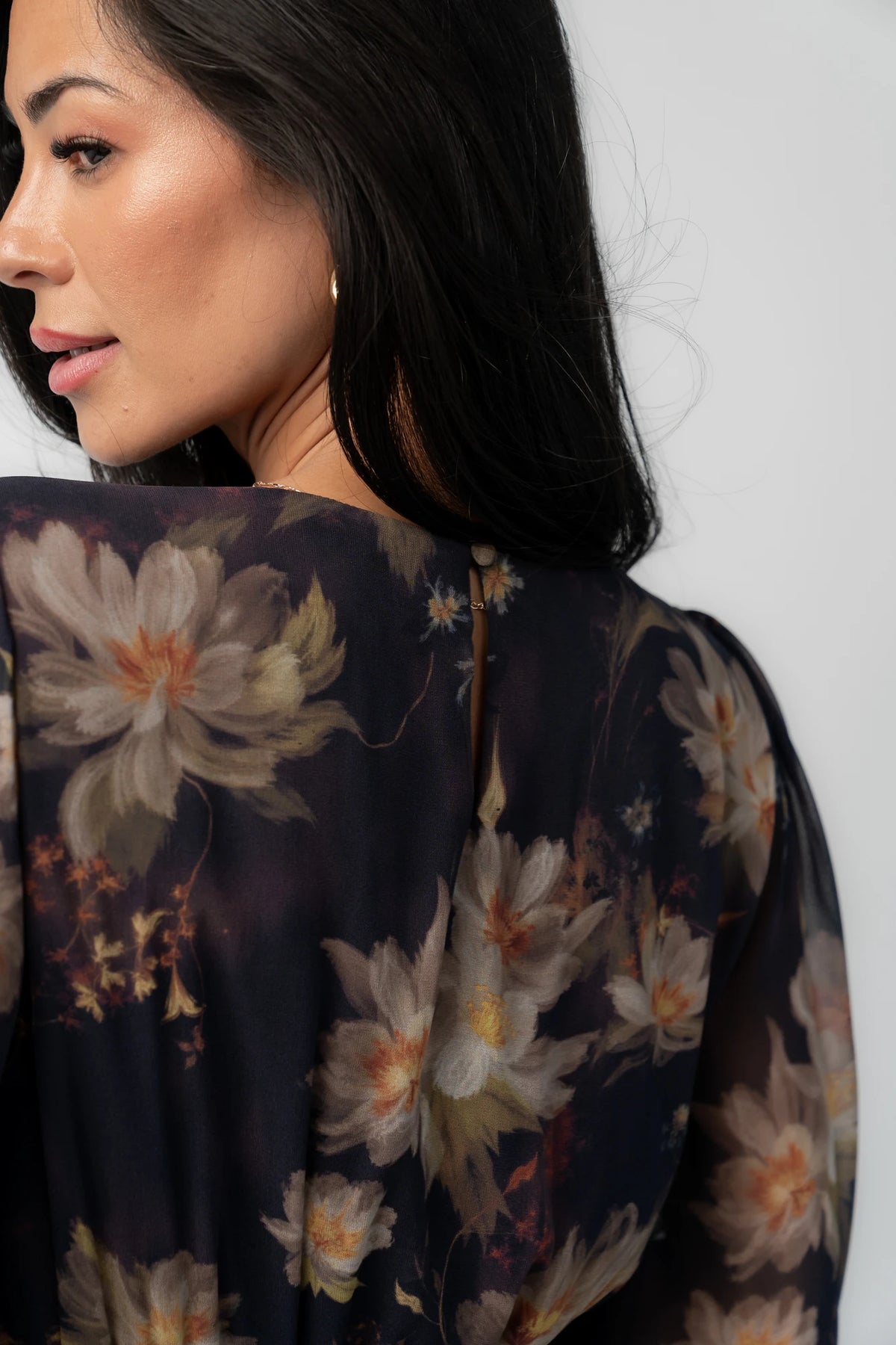 Model wearing the Mariella Tiered Maxi Dress featuring a V-neckline, long sheer puff sleeves, a smocked back waist, and a flowing tiered chiffon maxi skirt with a romantic floral print.