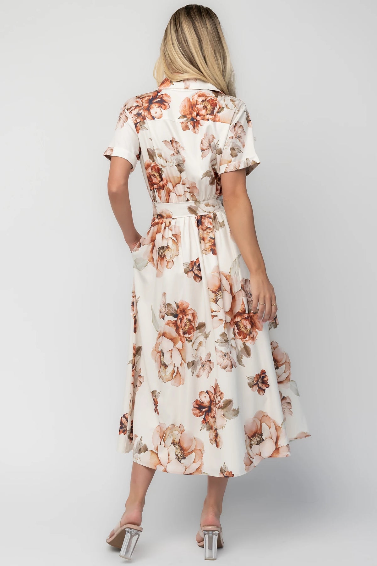 Model wearing the Blythe Midi Dress in Ivory Floral featuring a collared neckline, functional button-front bodice, short rolled sleeves, and a removable waist tie.