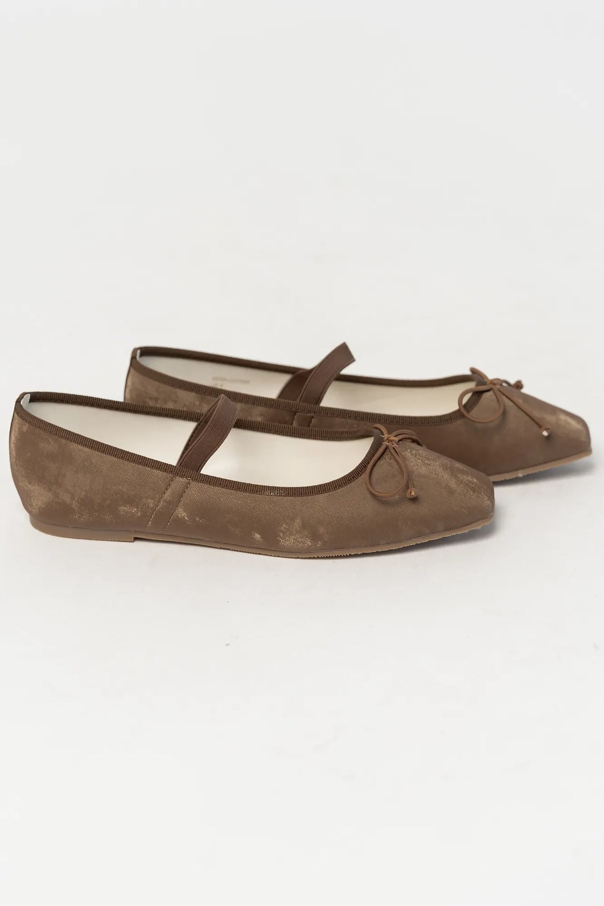 Pair of mocha velvet Mary Jane ballet flats featuring a square toe, delicate bow detail, and elastic strap across the foot. The classic flat silhouette offers a timeless, feminine look for everyday wear.