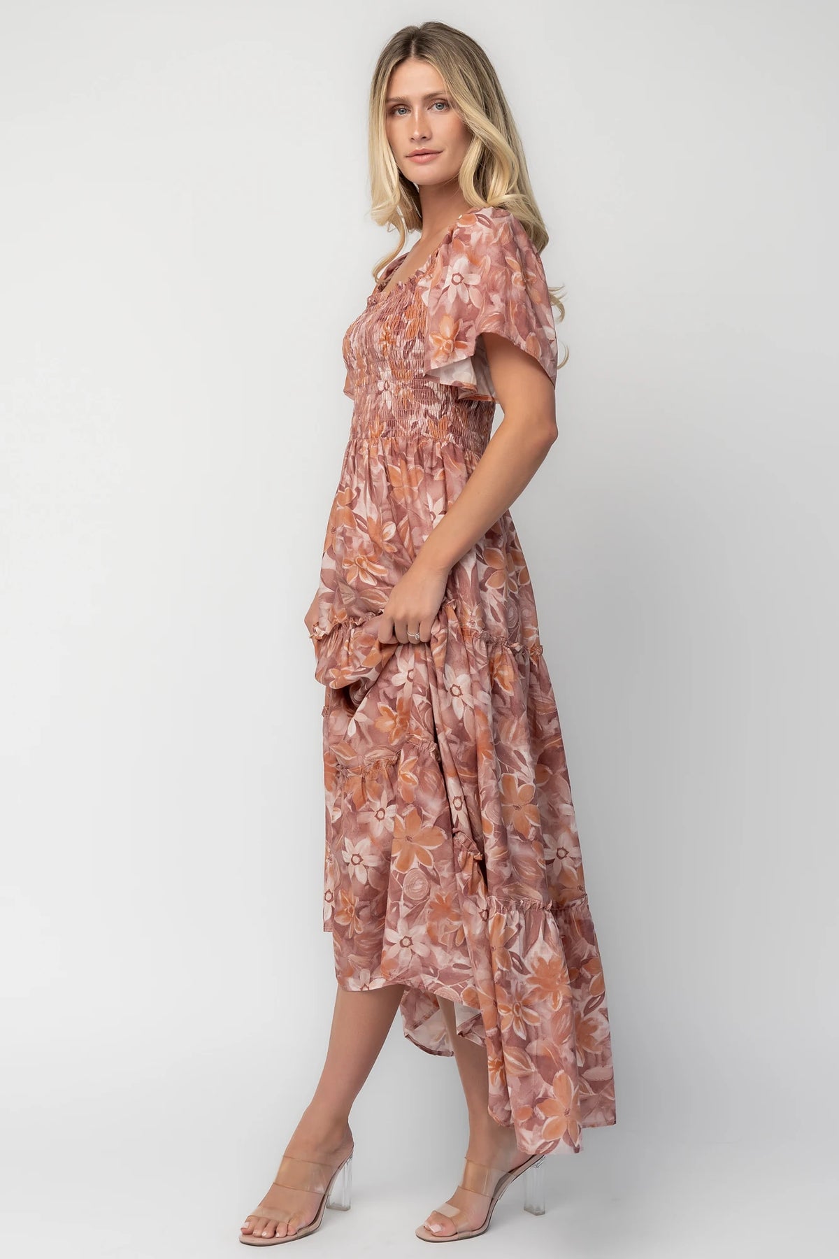 Model wearing the Southampton Smocked Maxi Dress in Dusty Mauve Floral featuring a square neckline, flutter sleeves with ruffle trim, a fully smocked bodice, and a flowing tiered maxi skirt with a dusty mauve floral print.