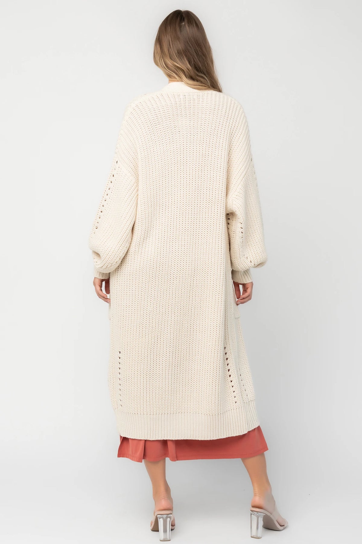 Natural chunky knit longline cardigan with an open front, pointelle detailing, balloon sleeves, ribbed trim, front patch pockets, and an oversized relaxed fit.