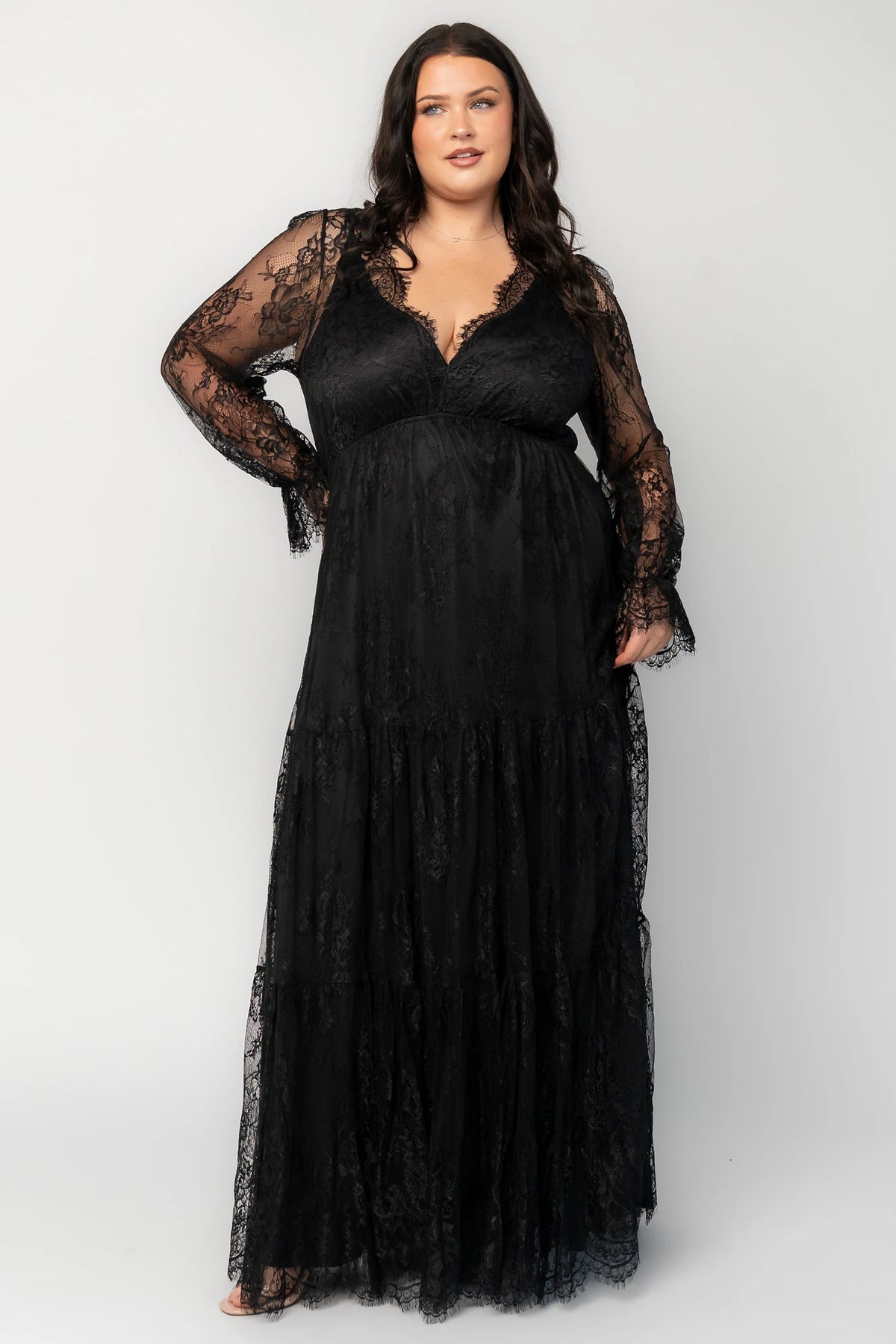 Gloria Lace Maxi Dress in Black with deep V-neck, sheer long sleeves, elastic waist, and three-tiered lace skirt.
