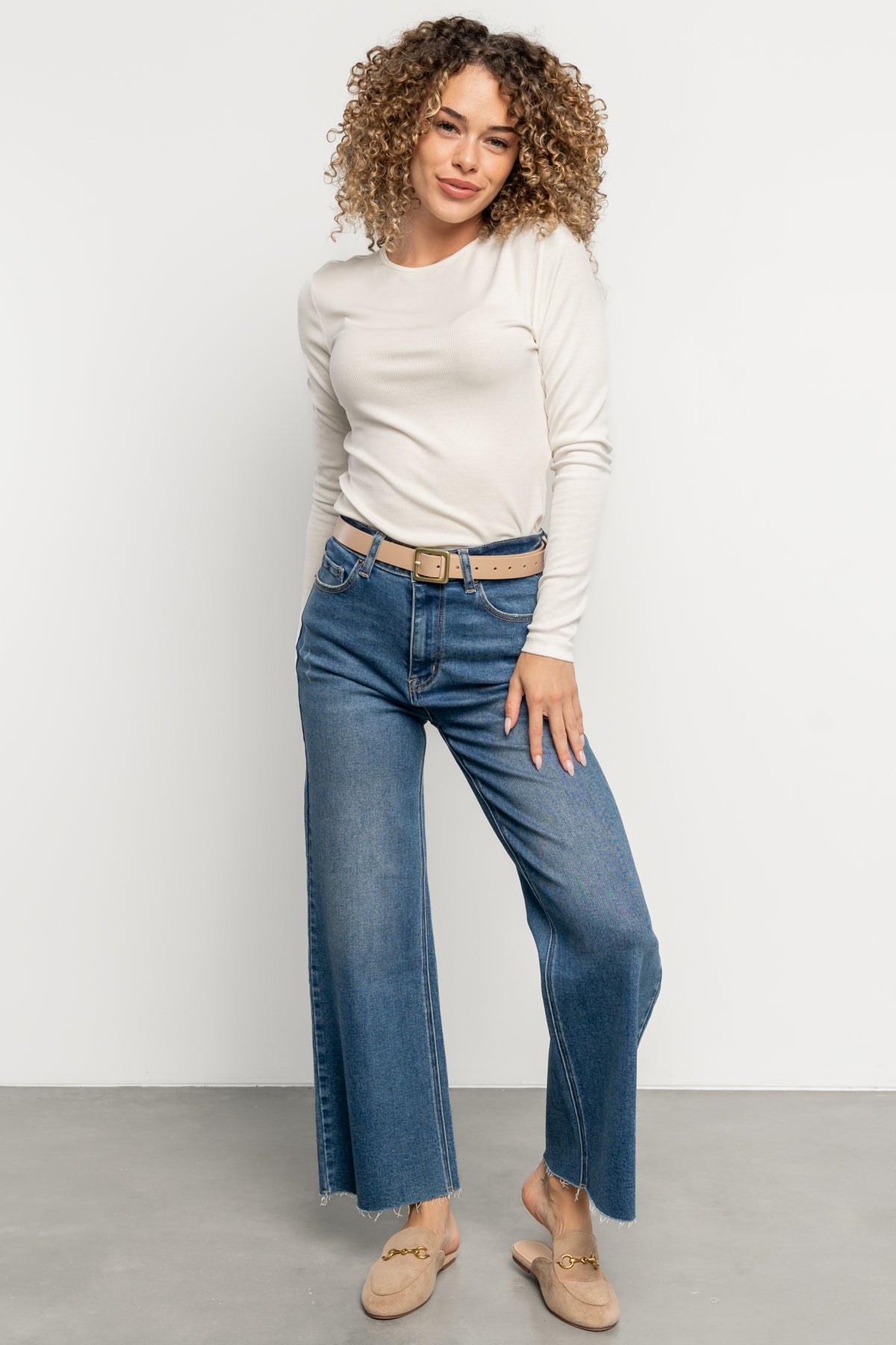 Side view of Deborah Buckle Belt on a neutral surface highlighting notch holes and clean minimal edge stitching in nude beige.