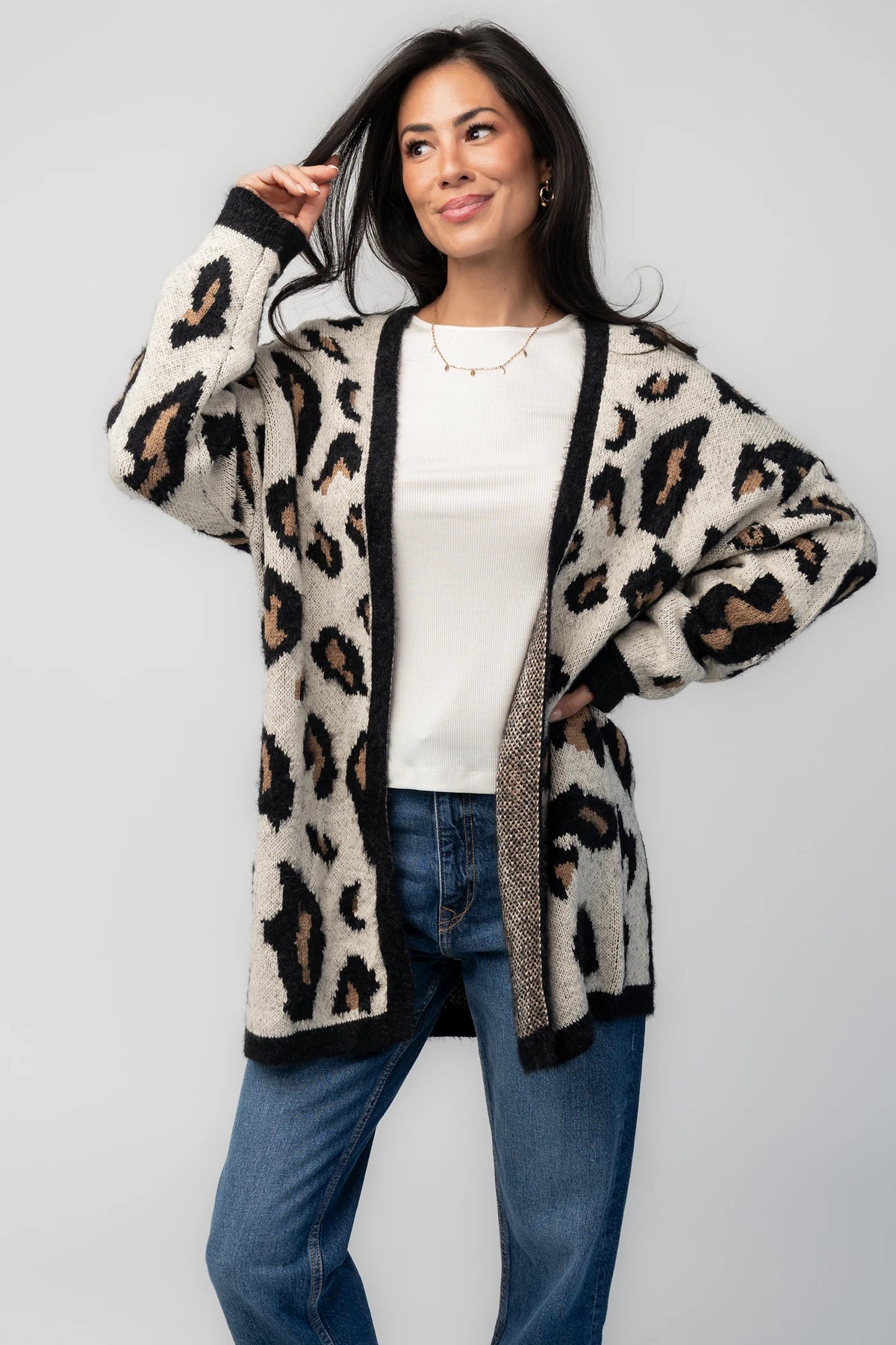 Model wearing the Jeter Open Cardigan in Leopard Print featuring a neutral knit with black and camel leopard print.