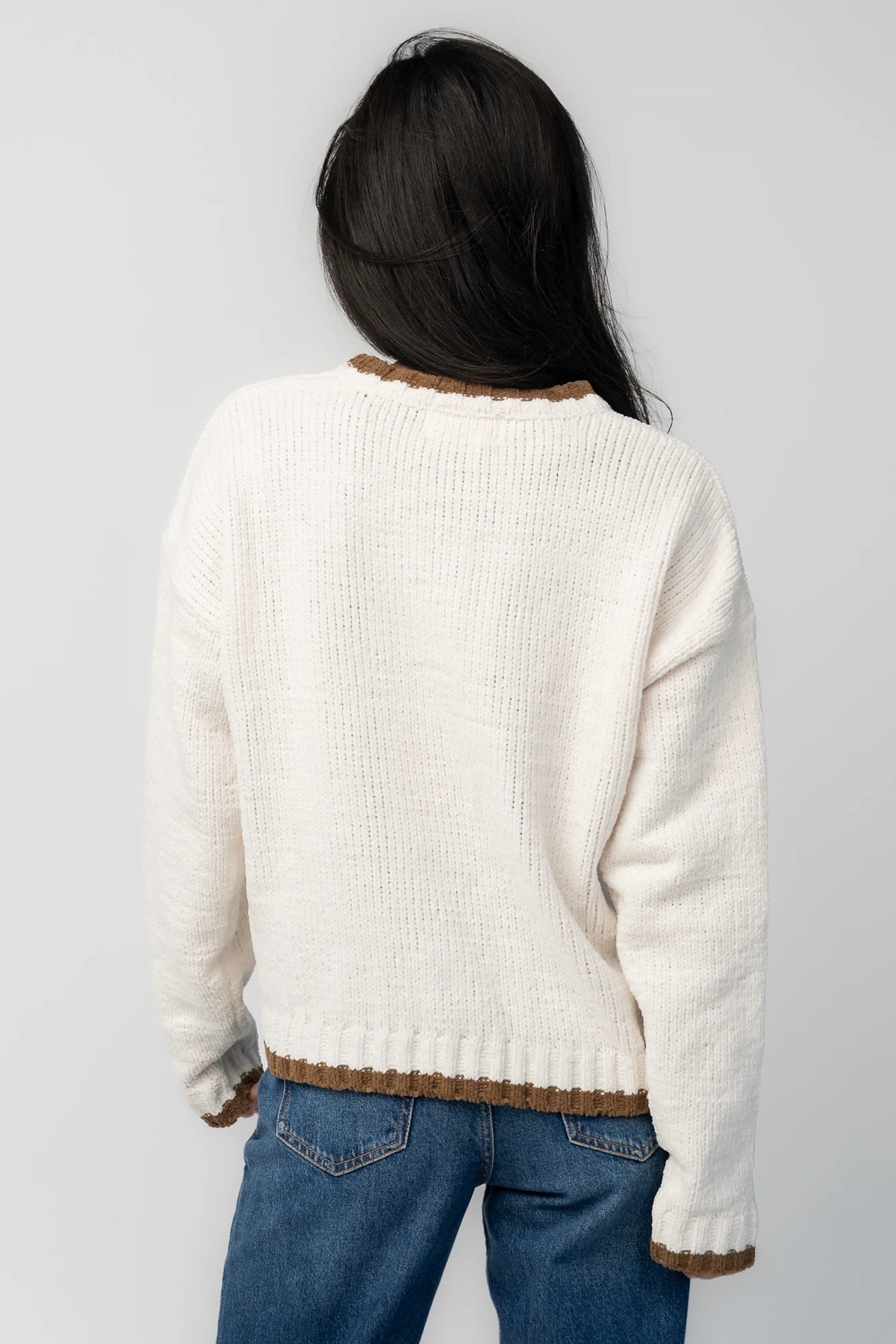 Model wearing the Wild West Knit Sweater in Cream featuring a relaxed fit, Western-inspired yoke detailing, textured knit stitching, long sleeves, and ribbed trim at the neckline, cuffs, and hem.