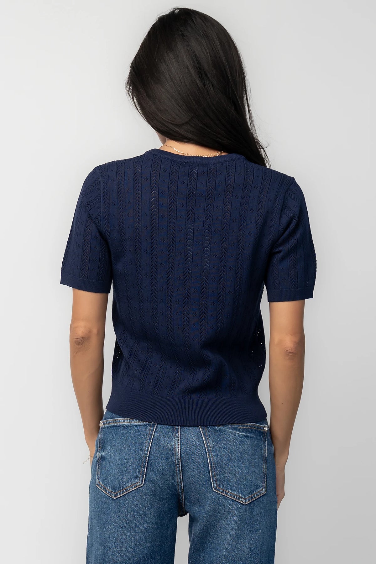 Pointelle knit top with a crew neckline, notch detail, short sleeves, and ribbed cuffs and hem.