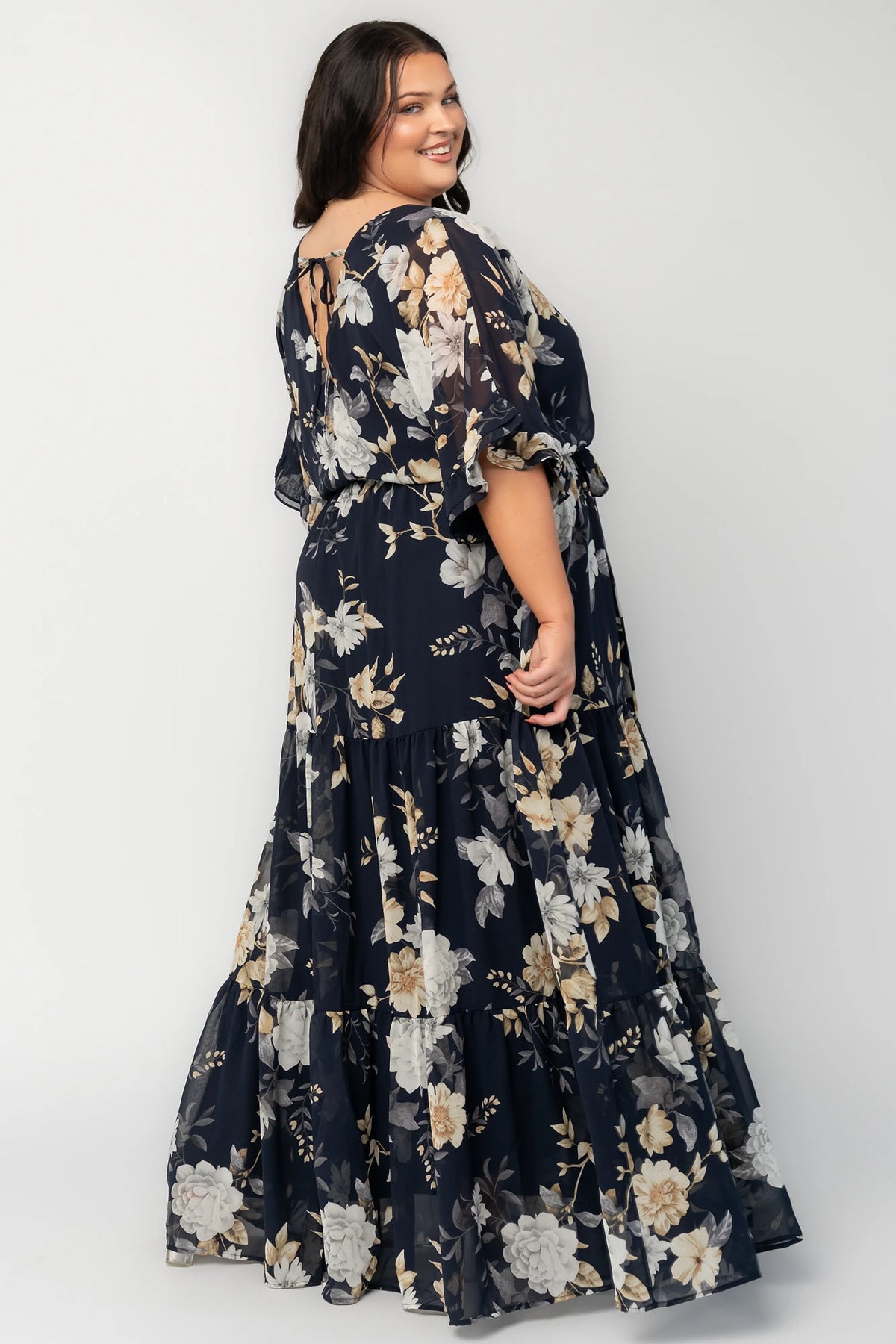 Luna Maxi Dress in Navy Floral with surplice V-neck, flutter sleeves, sash waist, and flowing tiered skirt.