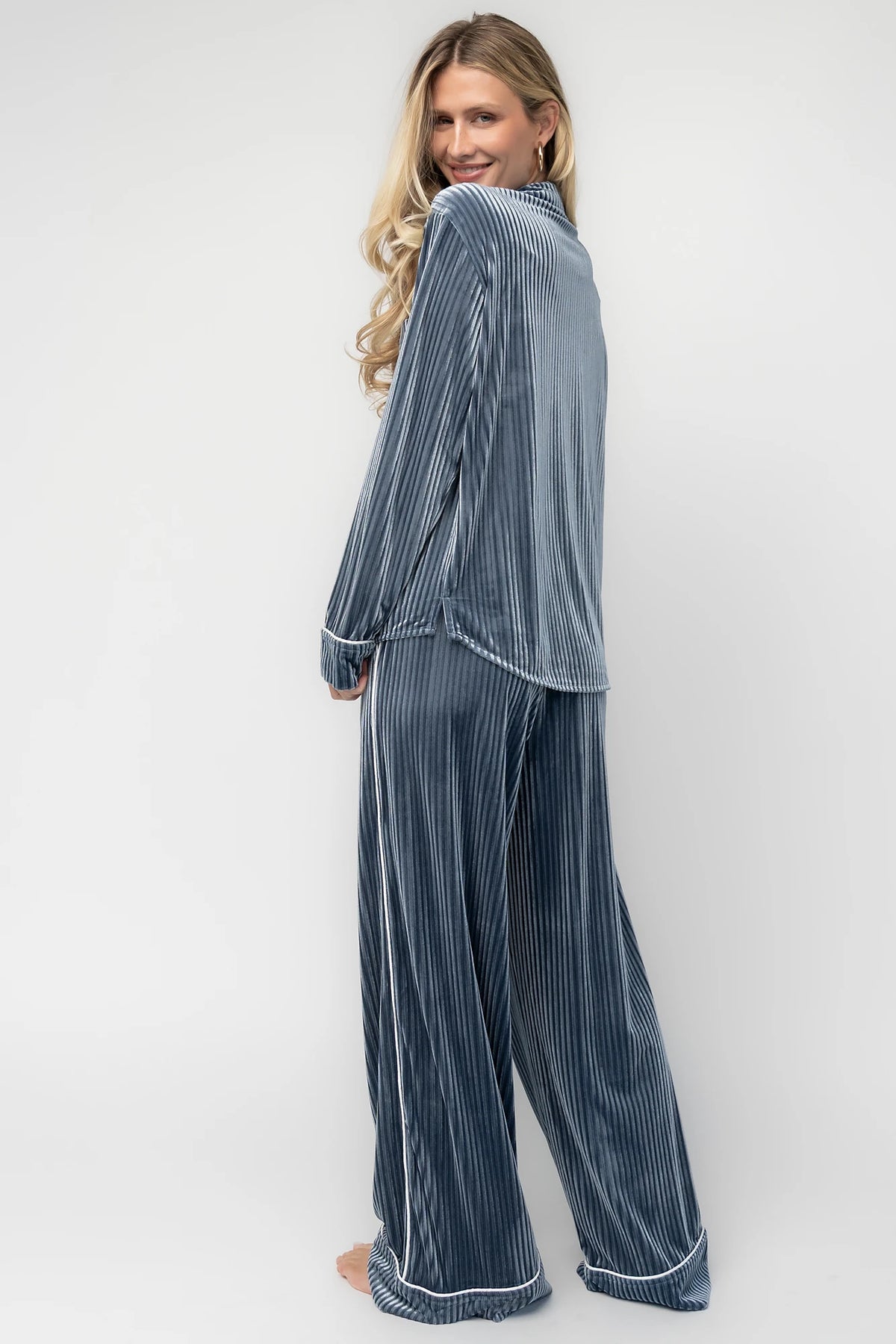 Dusty blue ribbed velvet pajama set with a collared button-front top, chest pocket, long sleeves, and wide-leg pants with an elastic drawstring waist and side pockets.