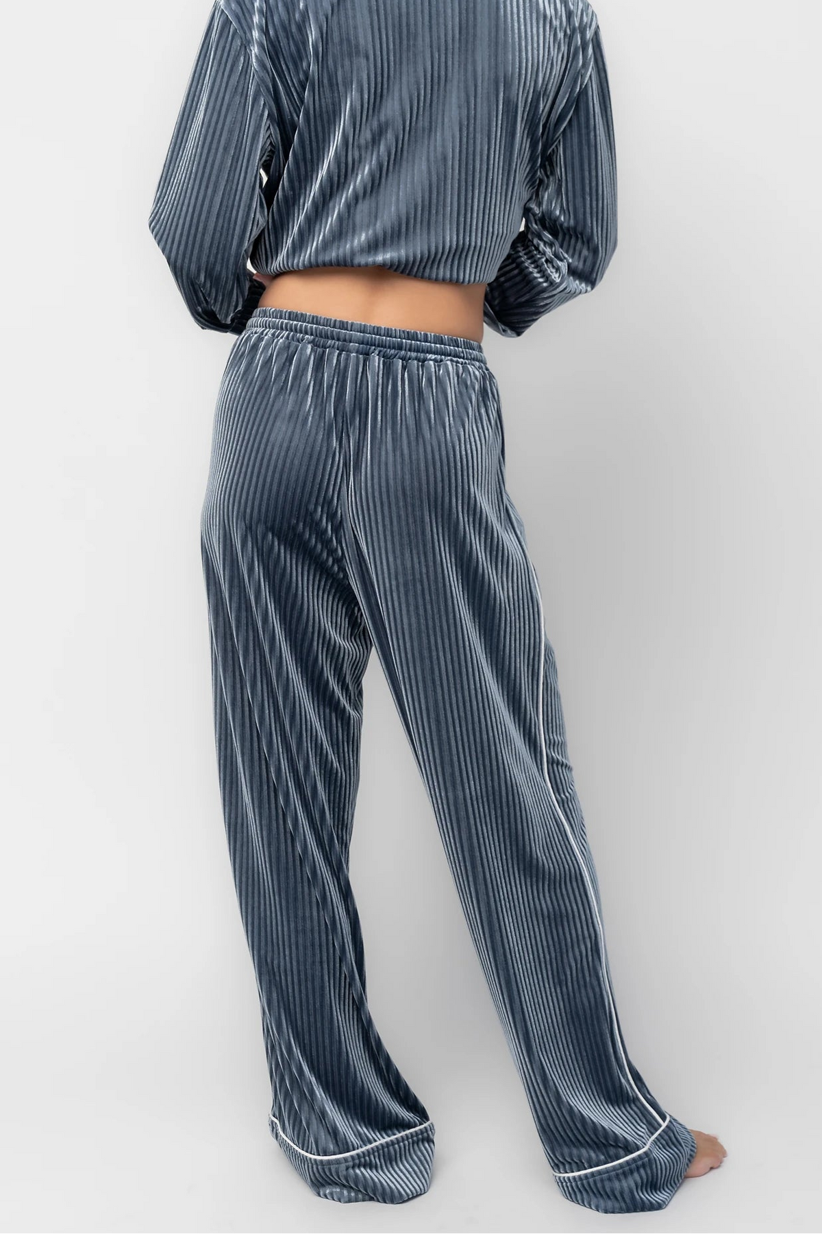 Dusty blue ribbed velvet pajama set with a collared button-front top, chest pocket, long sleeves, and wide-leg pants with an elastic drawstring waist and side pockets.