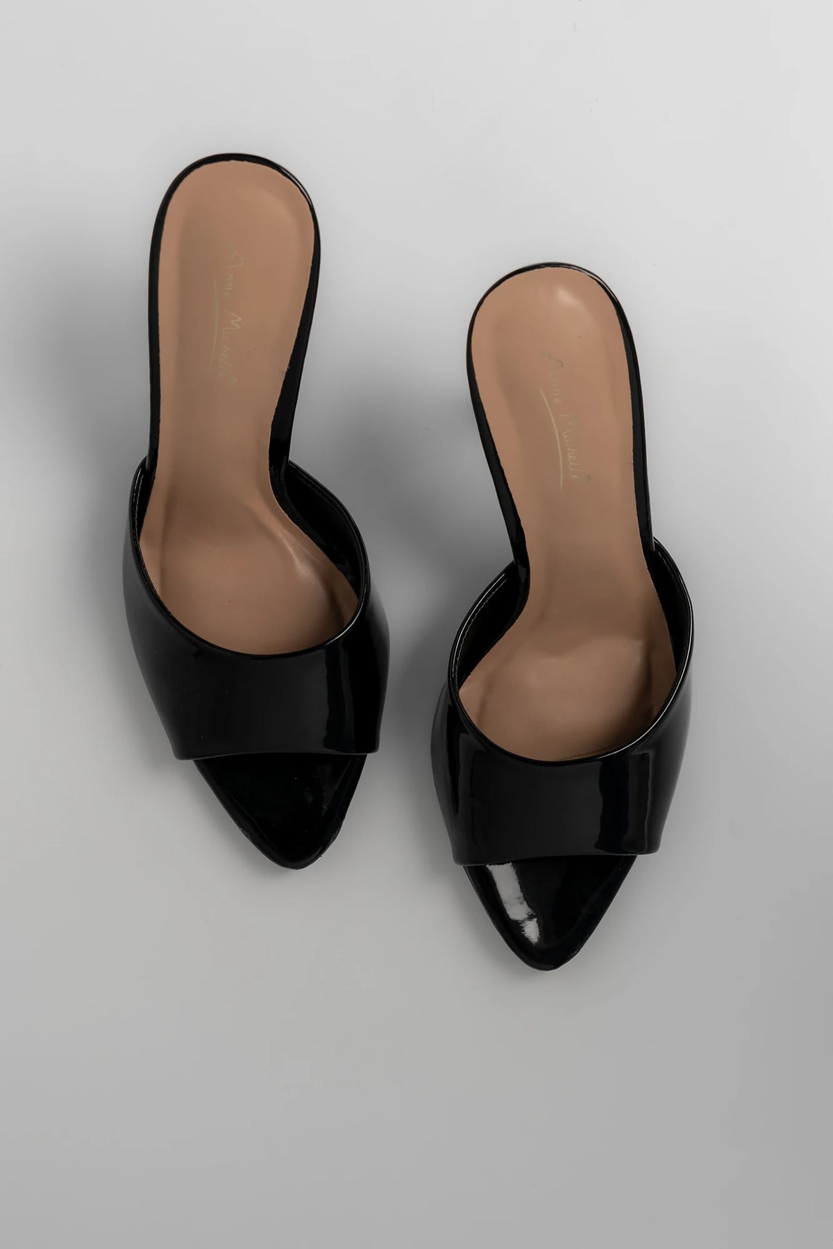Black patent mule heels with an open toe, slip-on design, and block heel.