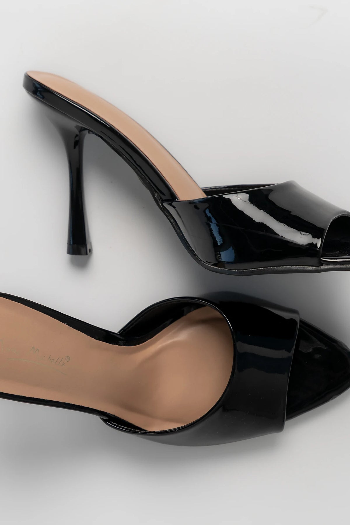 Black patent mule heels with an open toe, slip-on design, and block heel.