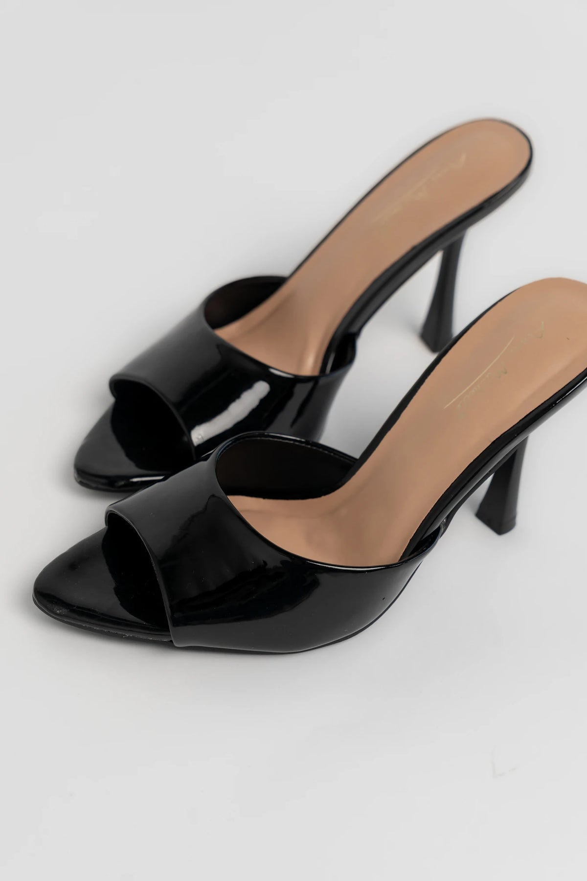 Black patent mule heels with an open toe, slip-on design, and block heel.