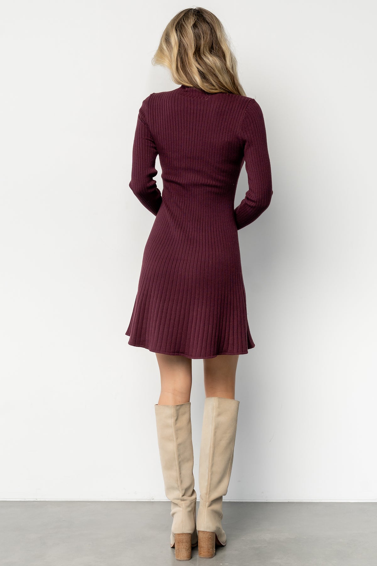 Close-up detail of the ribbed sweater-knit fabric in mulberry, showing stitch texture, soft hand, and the gently rolled edge at the mock neckline.