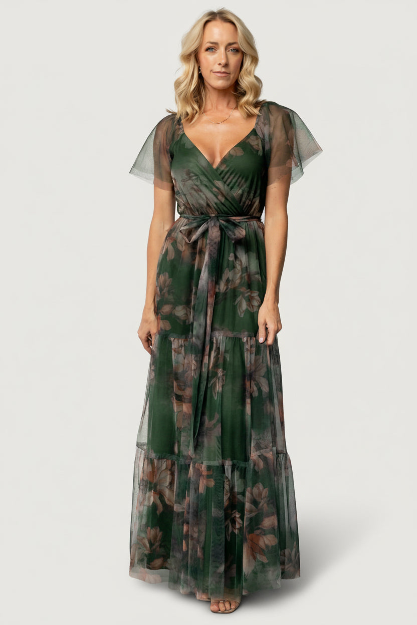 Front view of Nicola Tulle Maxi Dress in deep green floral on model, showing crossover surplice neckline and tiered maxi skirt.
