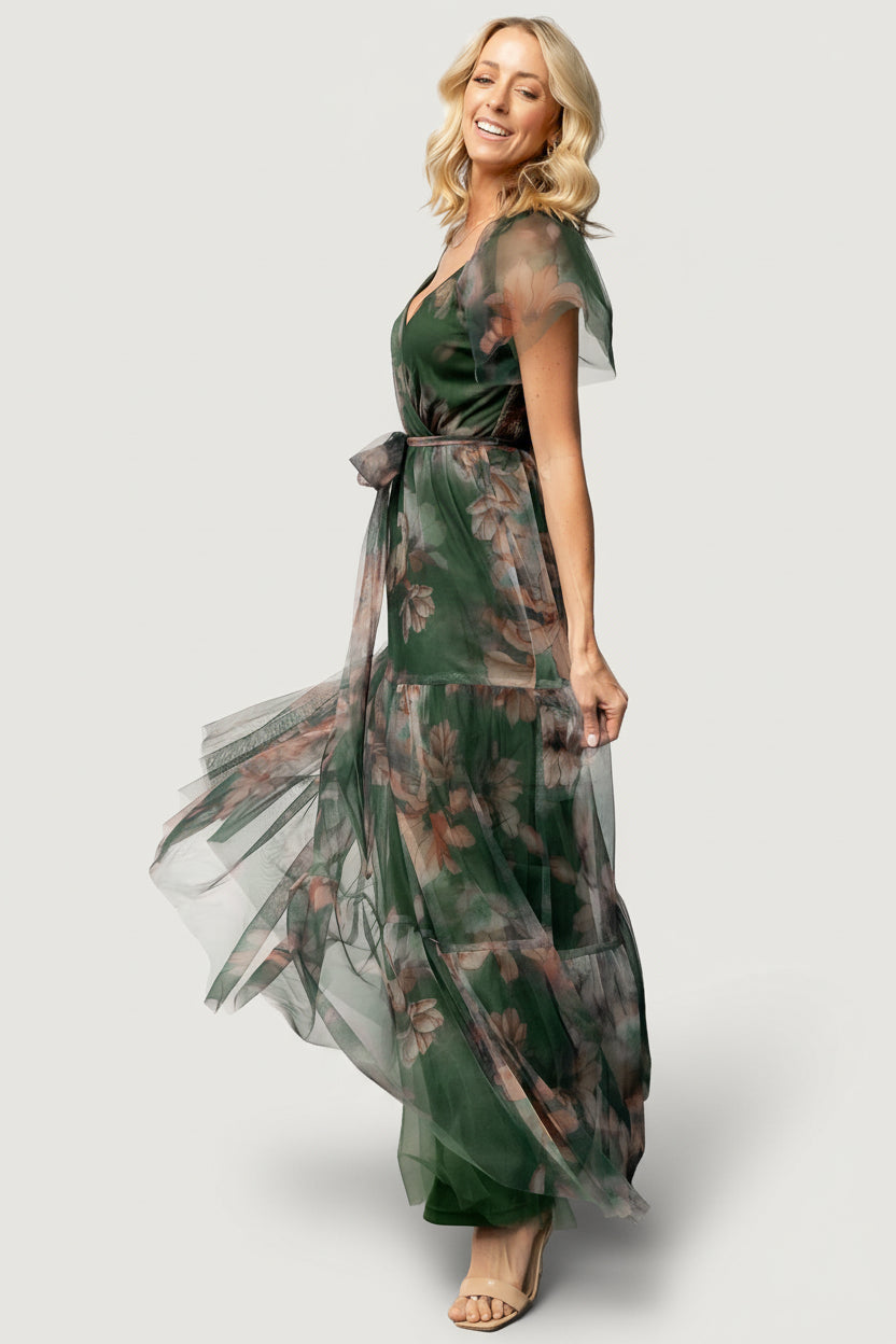 Detail shot of floral pattern and tulle texture on deep green maxi dress, emphasizing fabric layering and feminine print.