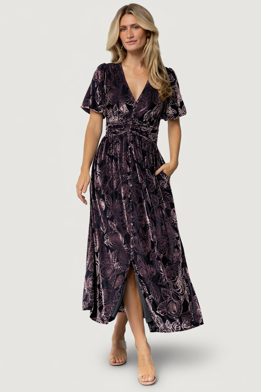 Back and movement shot of Dahlia embossed velvet dress, full skirt and gathered waist visible as model walks.