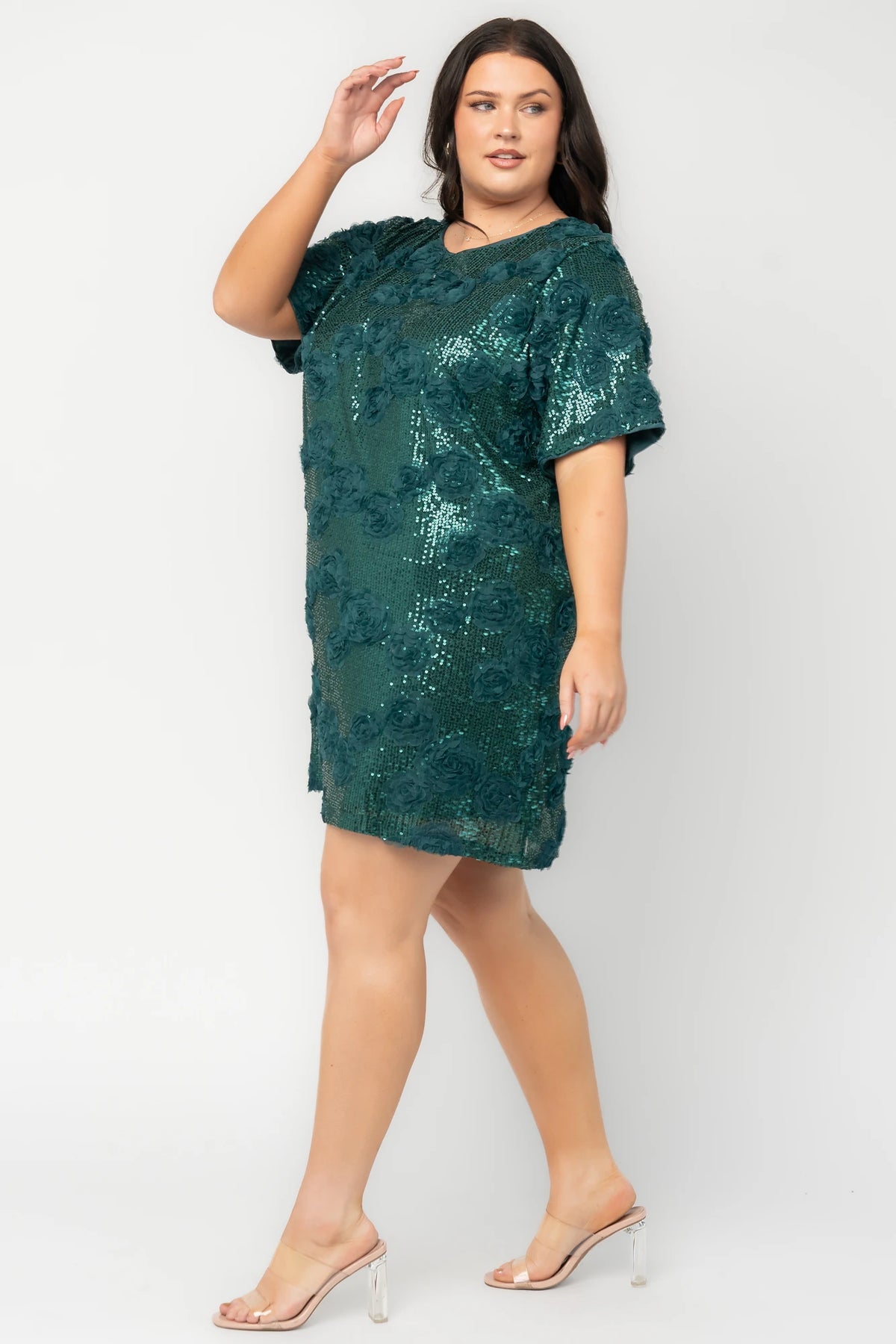 Model wearing a green short shift dress embellished with green sequins and floral appliqué detailing.