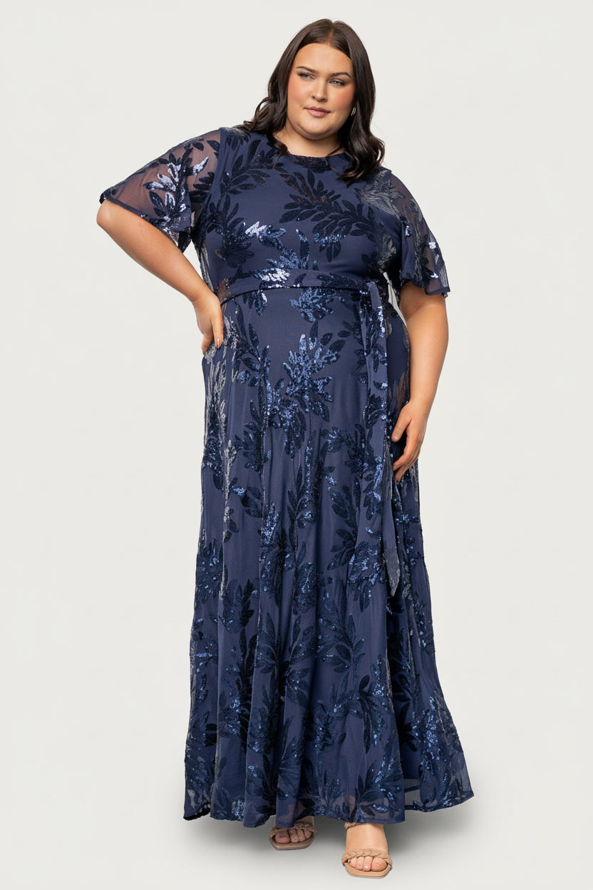 Close-up of navy sequin leaf detail and short sheer sleeve showing texture, sequins, and delicate fabric contrast with the lining.