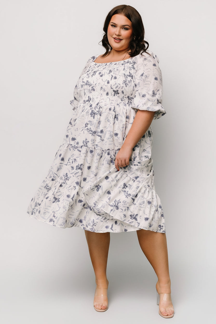 Full-length image of Marta Smocked Midi Dress in white and blue floral, styled with low heels for a spring event outfit.