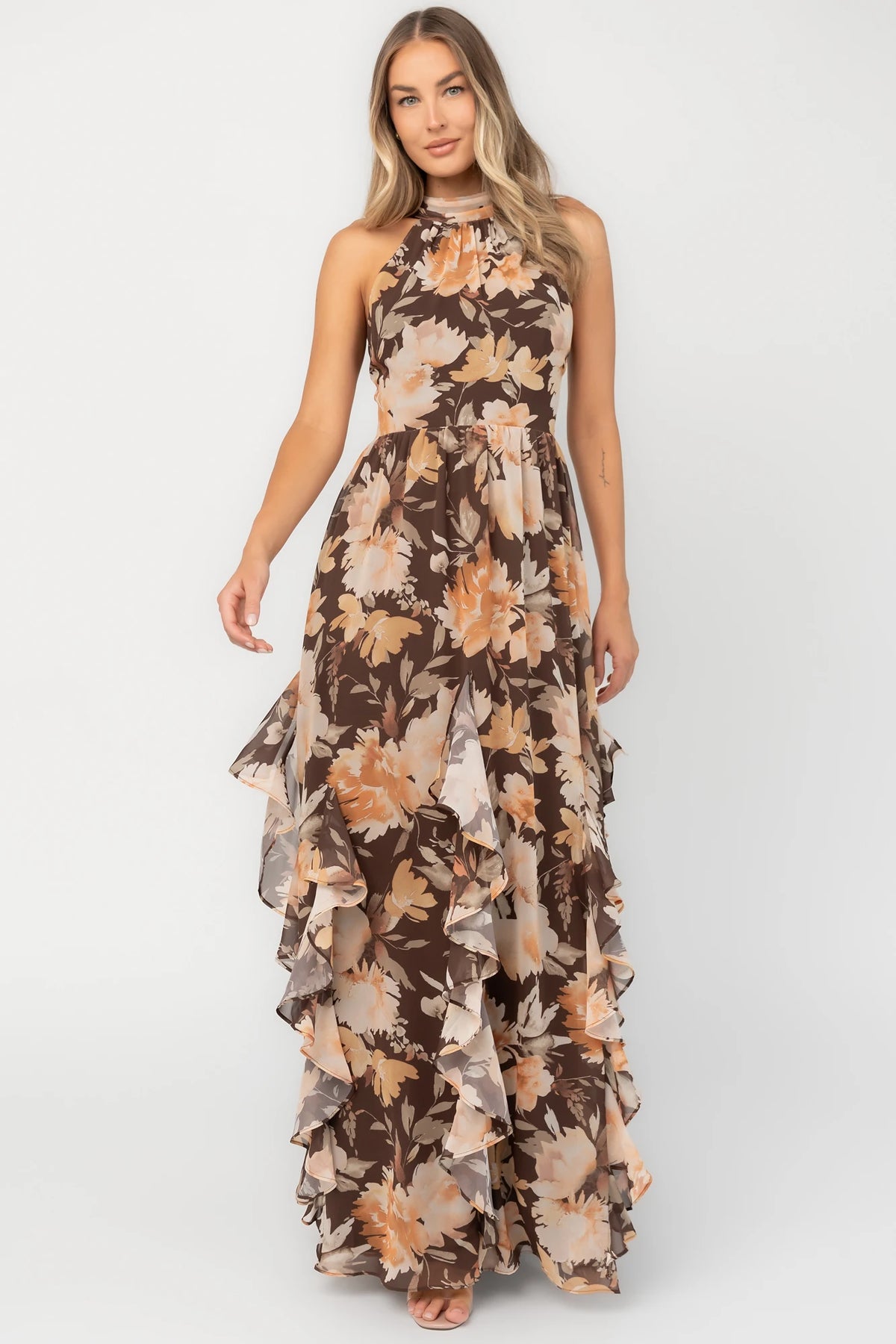 Brown and golden floral chiffon maxi dress with a high halter neckline, cascading ruffle details, smocked back waistband, and a flowing silhouette.
