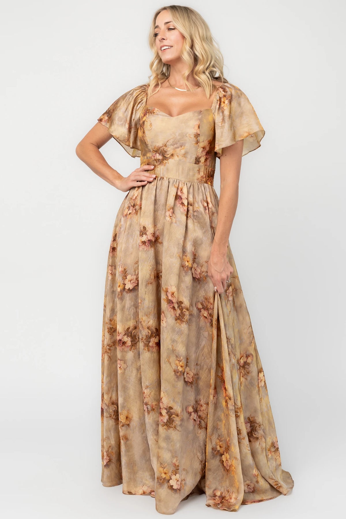 Golden floral maxi dress with a sweetheart neckline, flutter sleeves, smocked back bodice, empire waist, and flowing skirt.