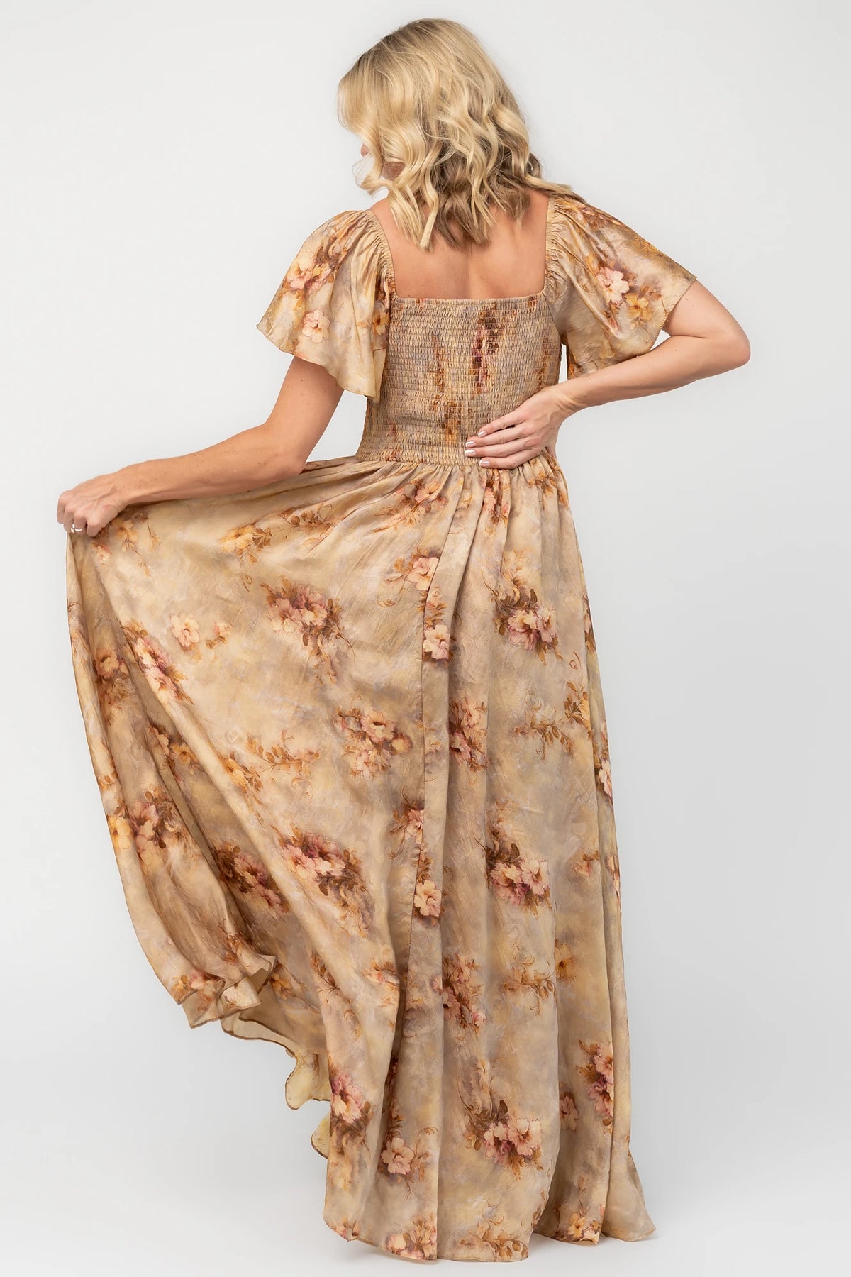 Golden floral maxi dress with a sweetheart neckline, flutter sleeves, smocked back bodice, empire waist, and flowing skirt.