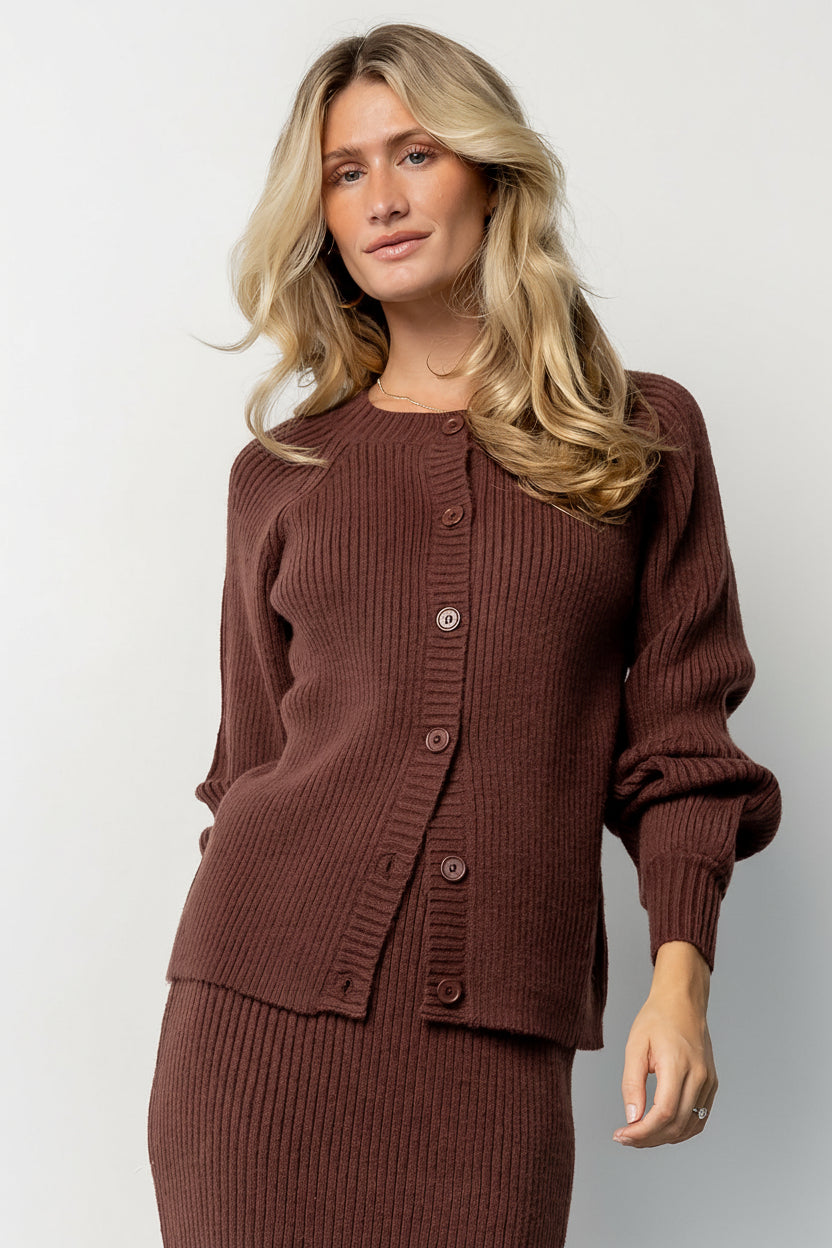 Front model view of the Blair mahogany rib knit cardigan showing three-button front, ribbed cuffs and hem, and a relaxed mid-length silhouette.