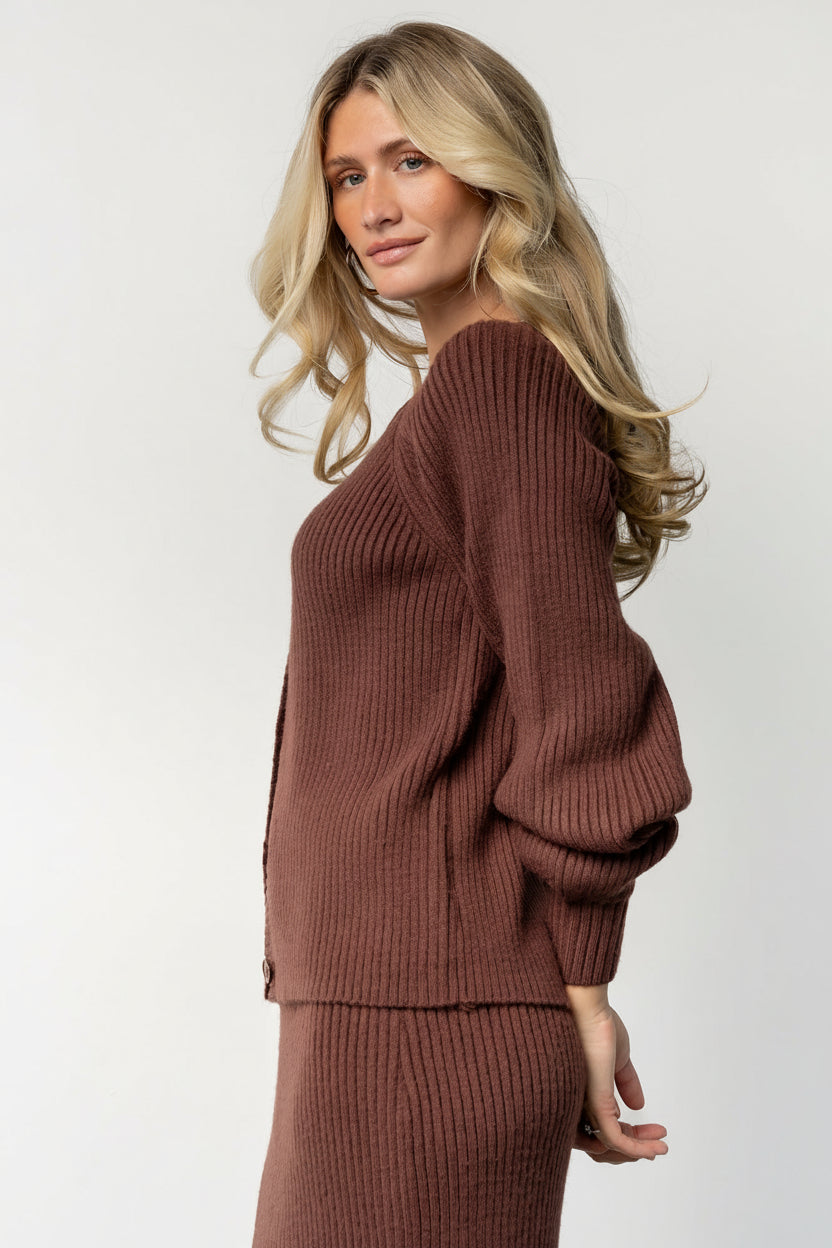 Side view of the Blair rib-knit cardigan in mahogany, displaying sleeve length, cuff ribbing, and the garment's subtle shaping at the hem.