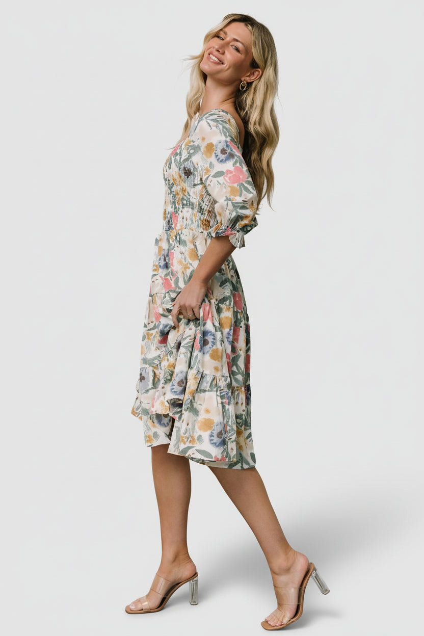 Side profile of the tiered midi dress highlighting the flowing silhouette, waistline fall, and layered skirt movement.
