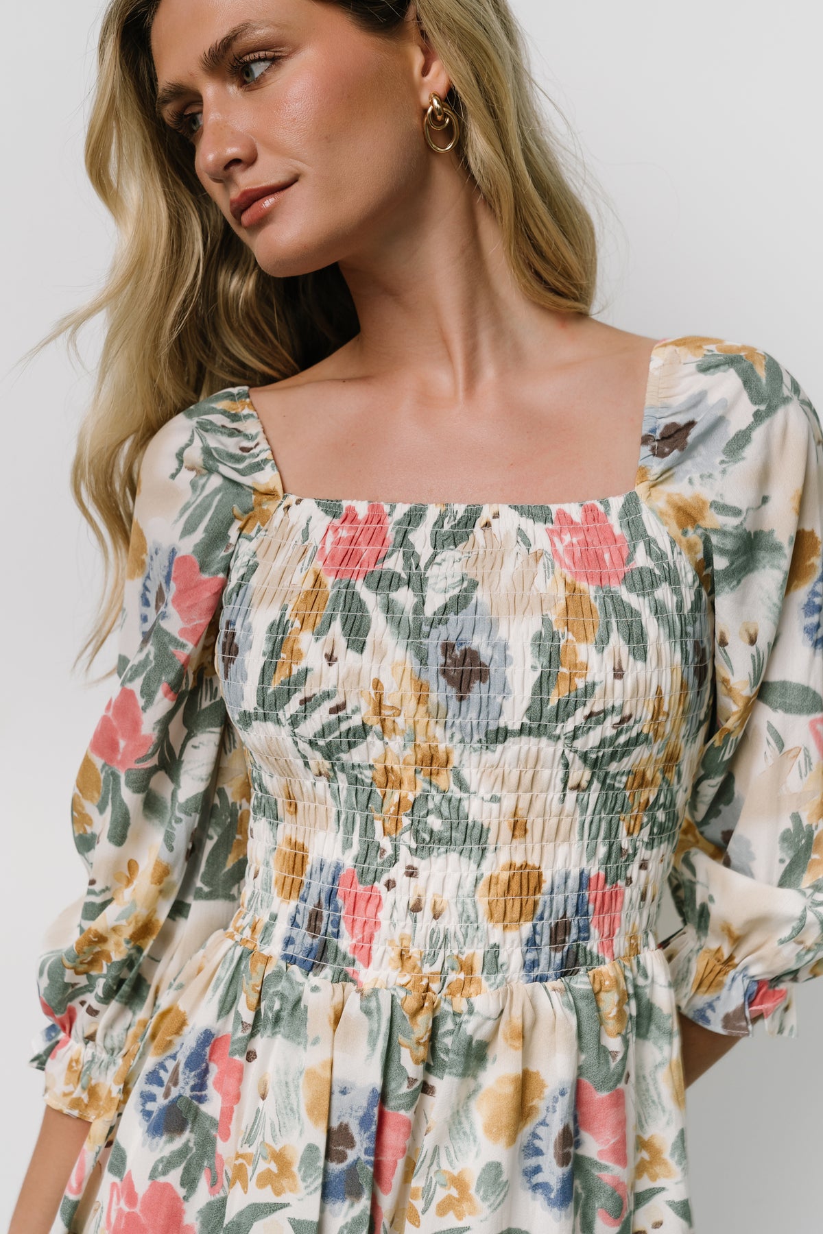Back view of the smocked midi dress showing the tiered skirt, hemline length, and gentle flare at the back.
