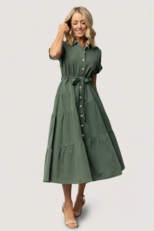 Three-quarter view of the washed green Logan Button Up Dress highlighting A-line tiered maxi skirt, diagonal seam detail, and lightweight unlined construction.