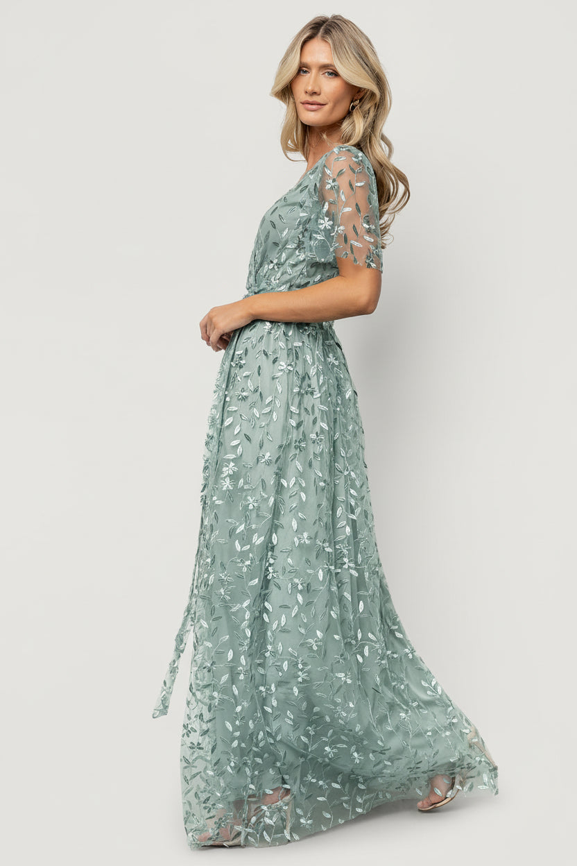 Side view of maxi dress emphasizing left-side slit, gentle drape of the organza overlay, and the elastic waistband with removable waist tie.