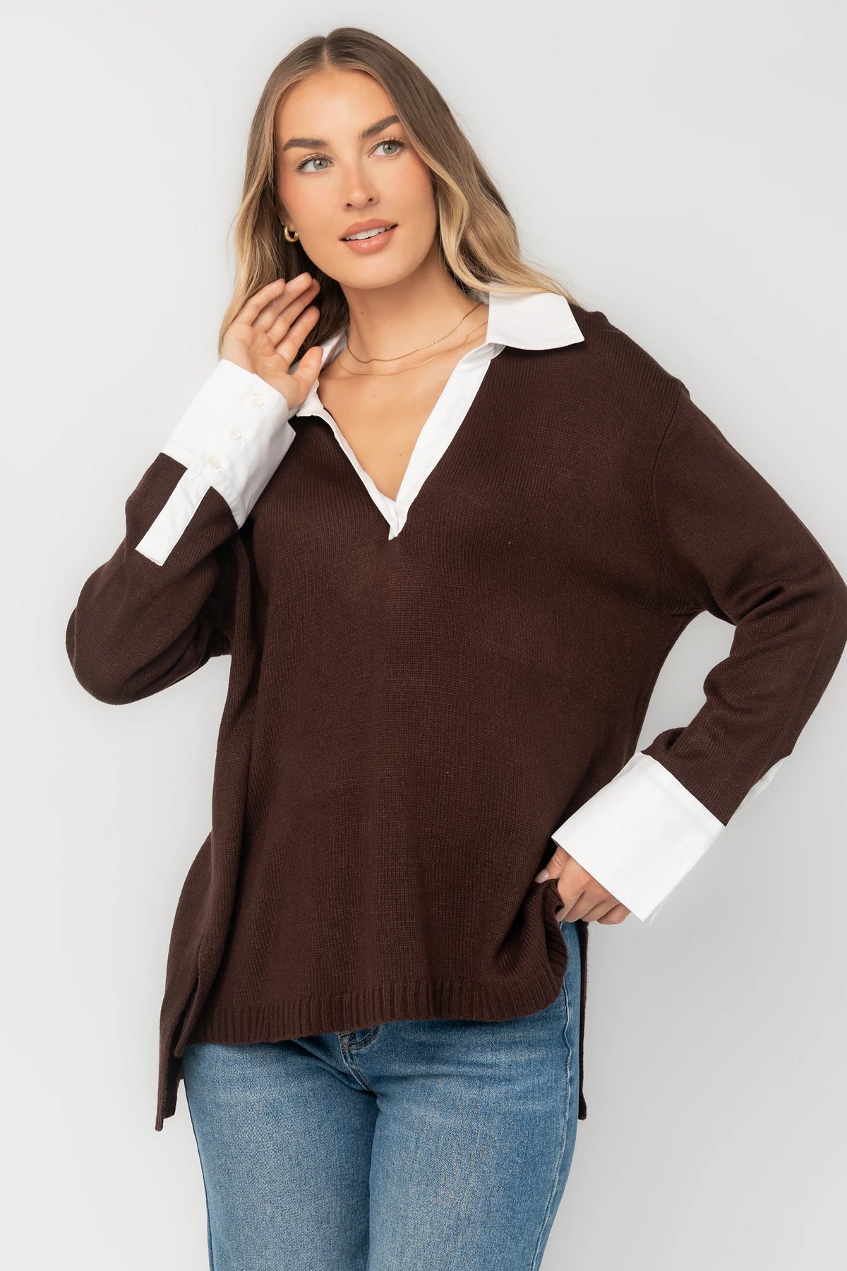 Chocolate sweater top with a contrast white collared neckline and cuffs, split V-neck, long sleeves, side hem slits, ribbed hem, and a relaxed fit.