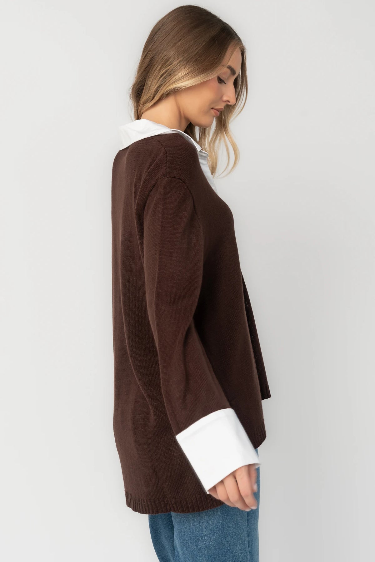 Chocolate sweater top with a contrast white collared neckline and cuffs, split V-neck, long sleeves, side hem slits, ribbed hem, and a relaxed fit.