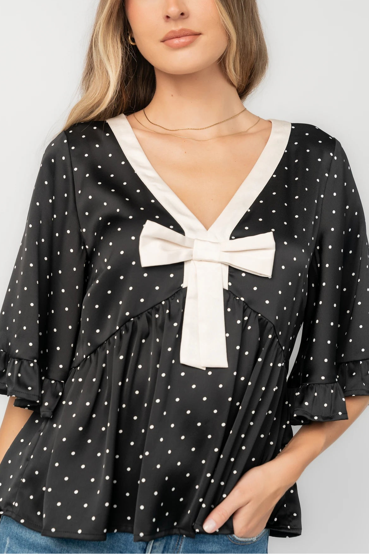 Carrie Bow Front Top in Black + Ivory Dot with contrast collar, bow detail, V-neck, ruffle sleeves, and peplum hem.