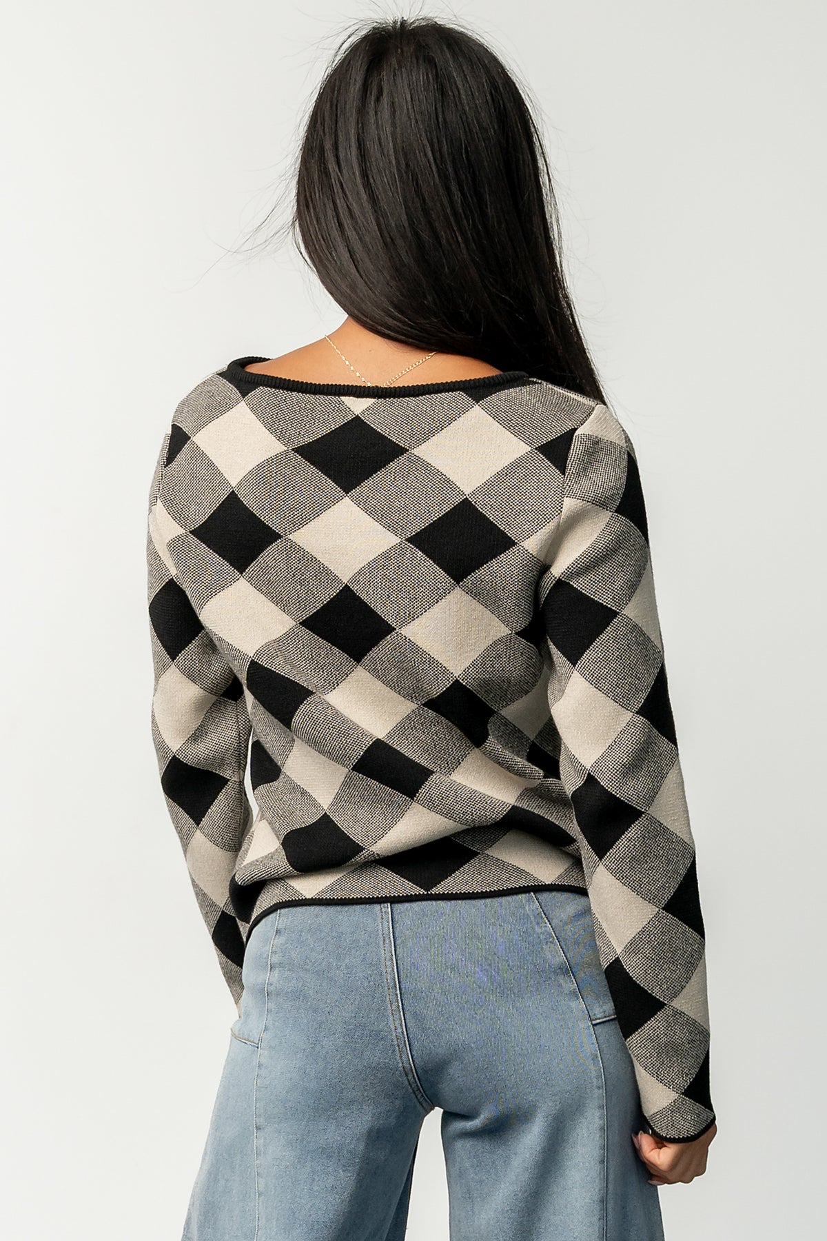 Back and side view of Linnea sweater on model, displaying overall silhouette, sleeve length, and how the ribbed hem rests at the waist.