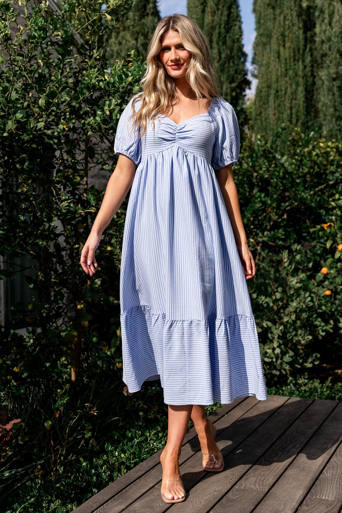 Full-length front view of Poppy Midi Dress in blue with off-white stripes, showing sweetheart neckline, short sleeves, and tiered midi skirt.