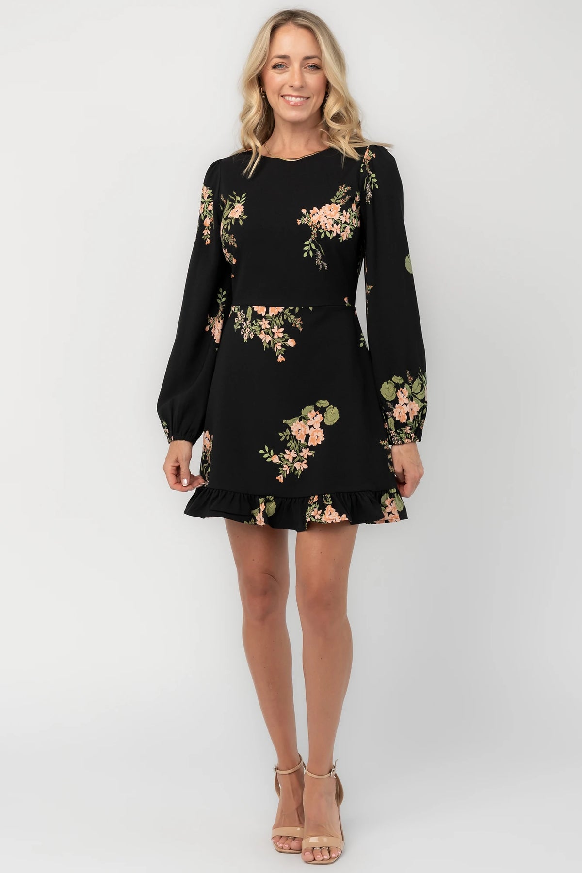 Black floral mini dress with a round neckline, long sleeves, fitted bodice, ruffle hem, back keyhole tie, and hidden back zipper.