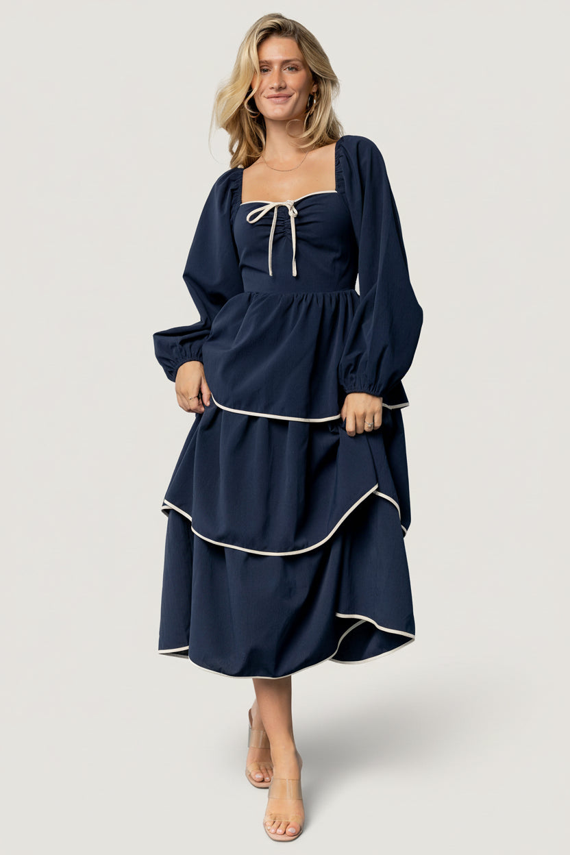 Back view highlighting the smocked back bodice, natural waist, and fully lined skirt of the navy Barcelona tiered dress.
